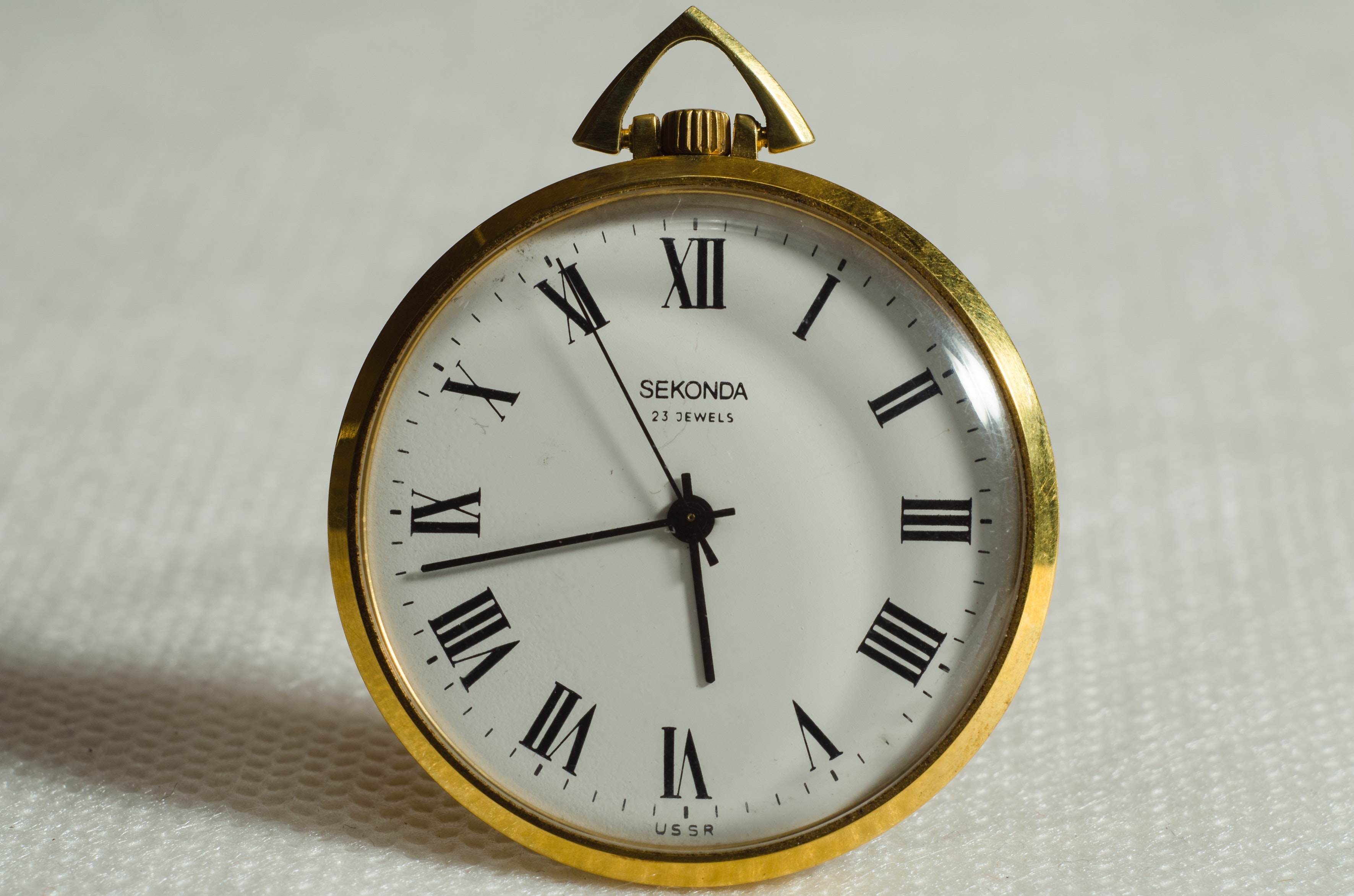 Brass pocket watch pointing at 5 43 photo