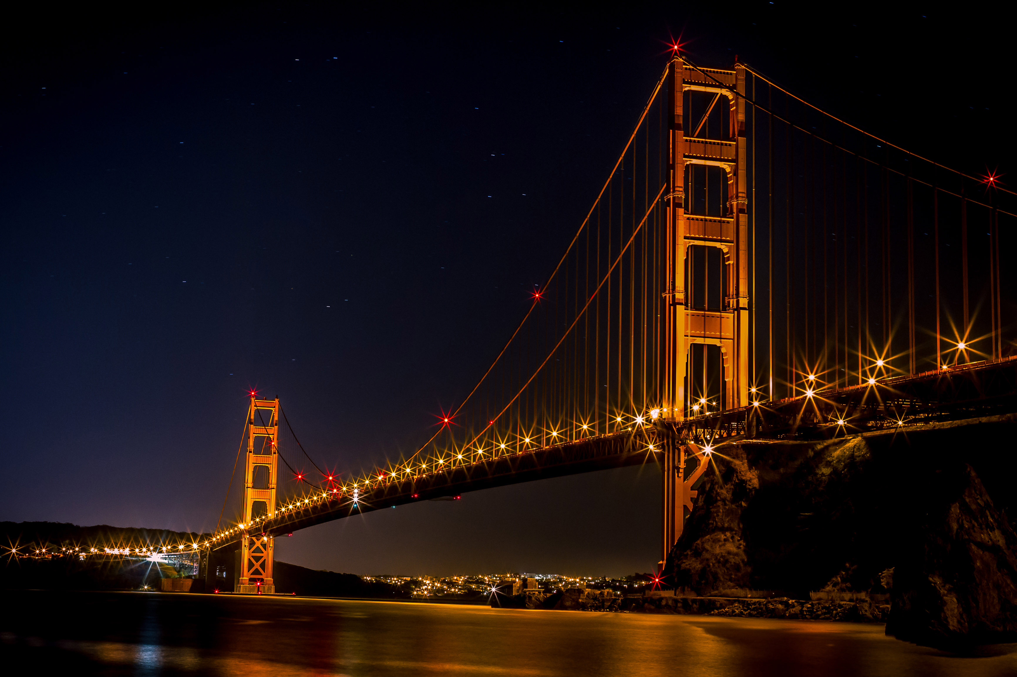 Golden Gate Bridge over the bay at night illuminated in Gold in San ...