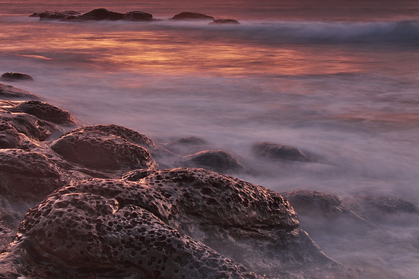 Brown and black rock formations with fog during sunset photo