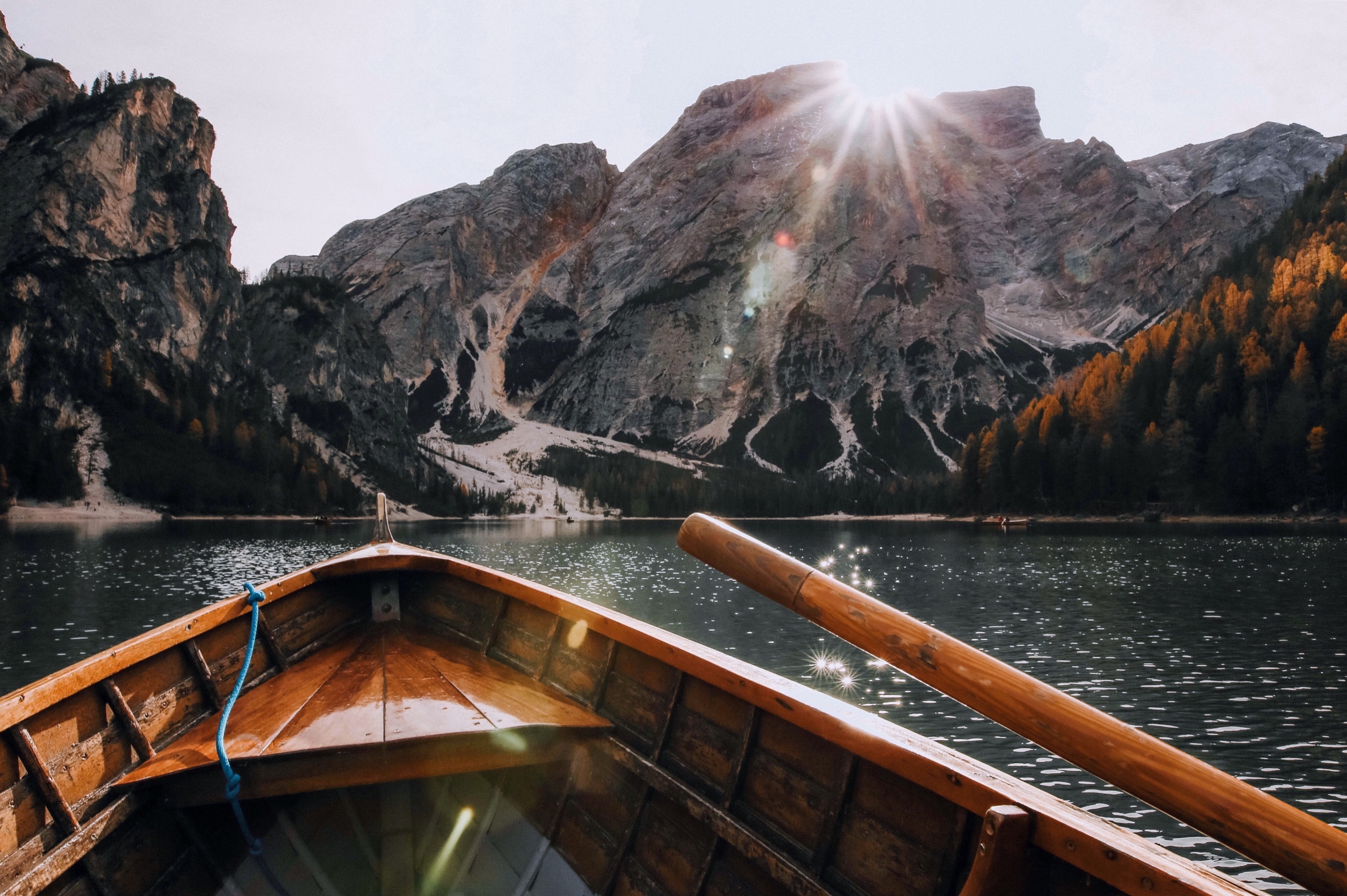 Brown canoe in the body of water near mountain photo