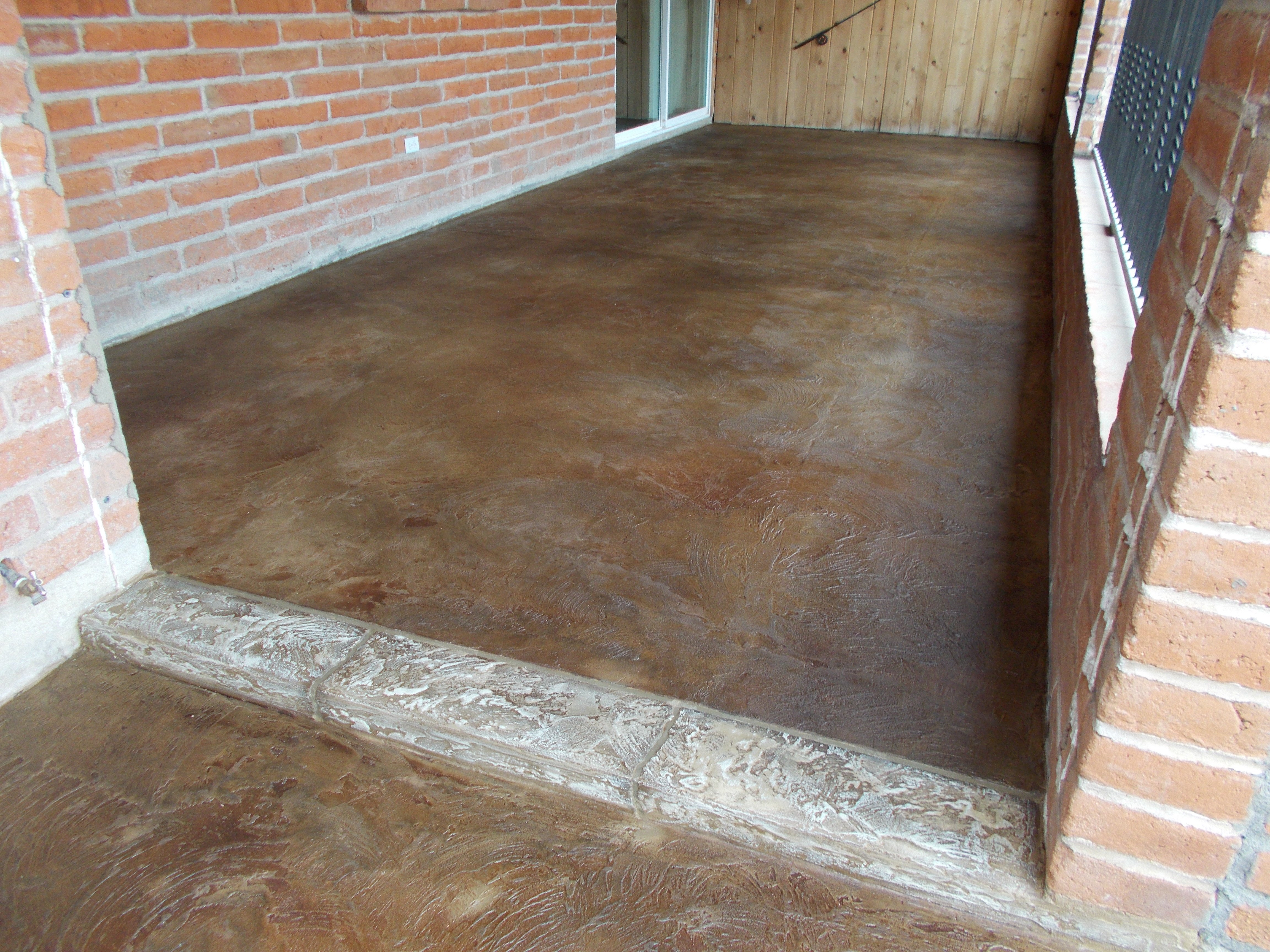 brown Stained Concrete Patio floor with stacked red brick stone wall ...