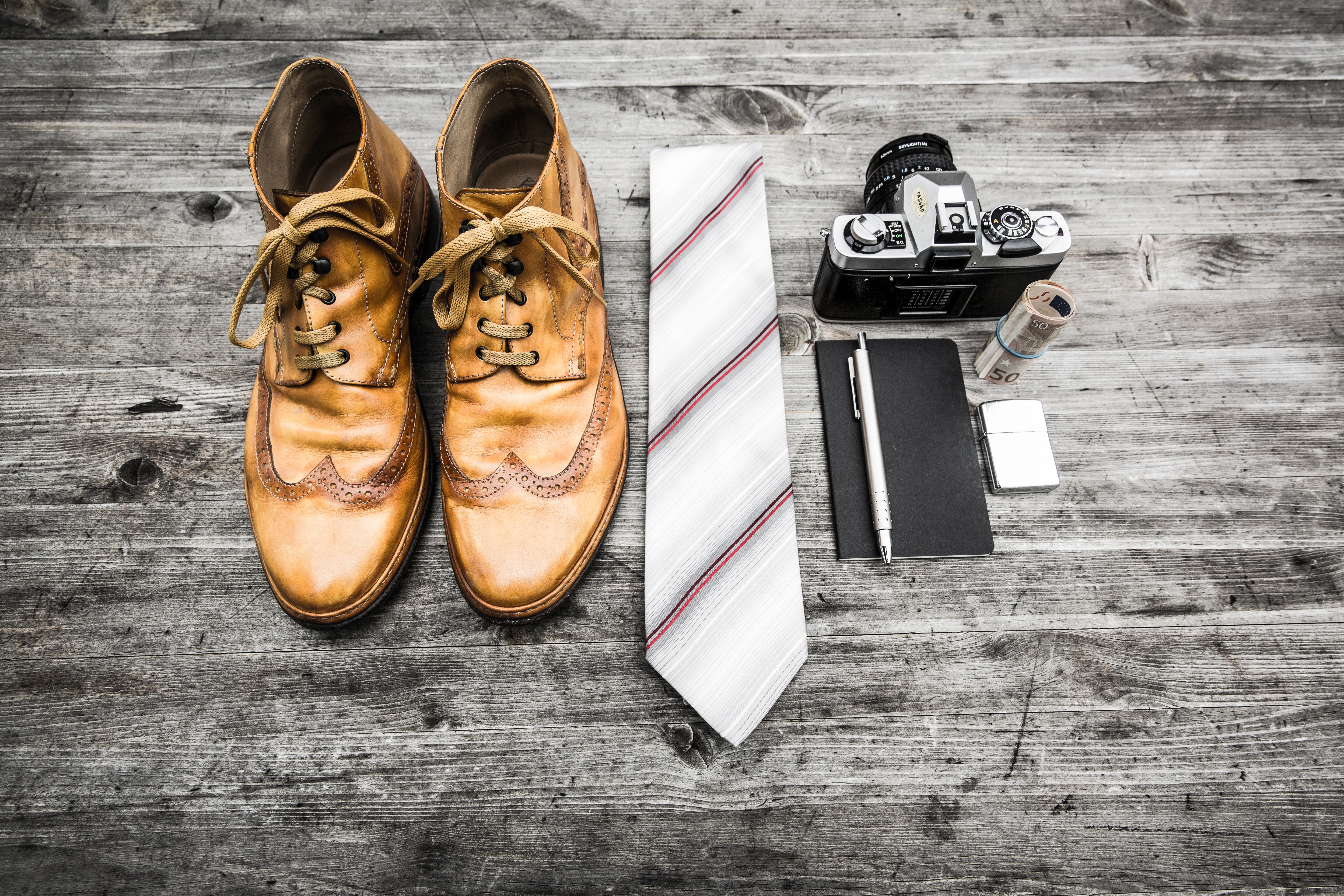 Brown leather oxford wingtip shoes beside white and red necktie photo