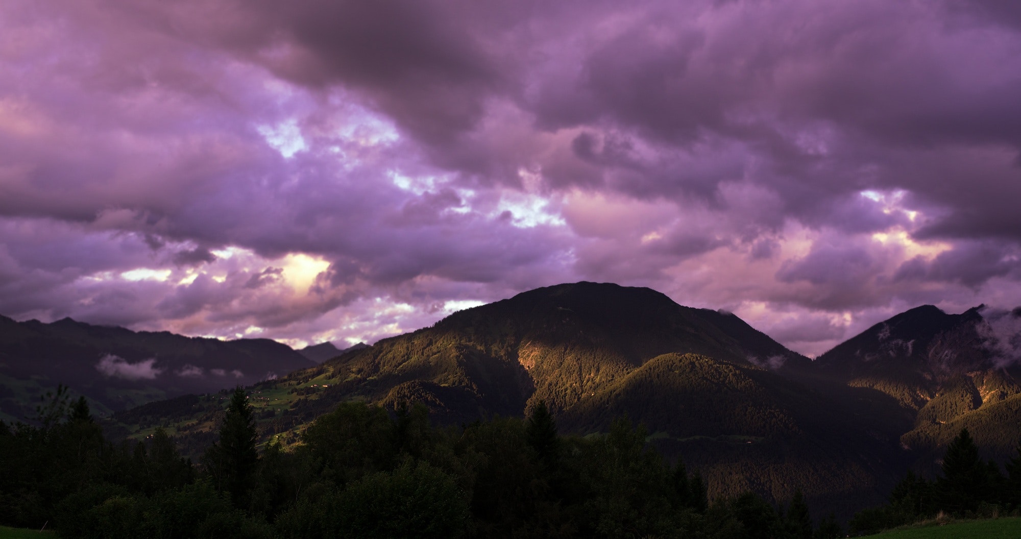 Brown mountain under cloudy sky during sunset photo