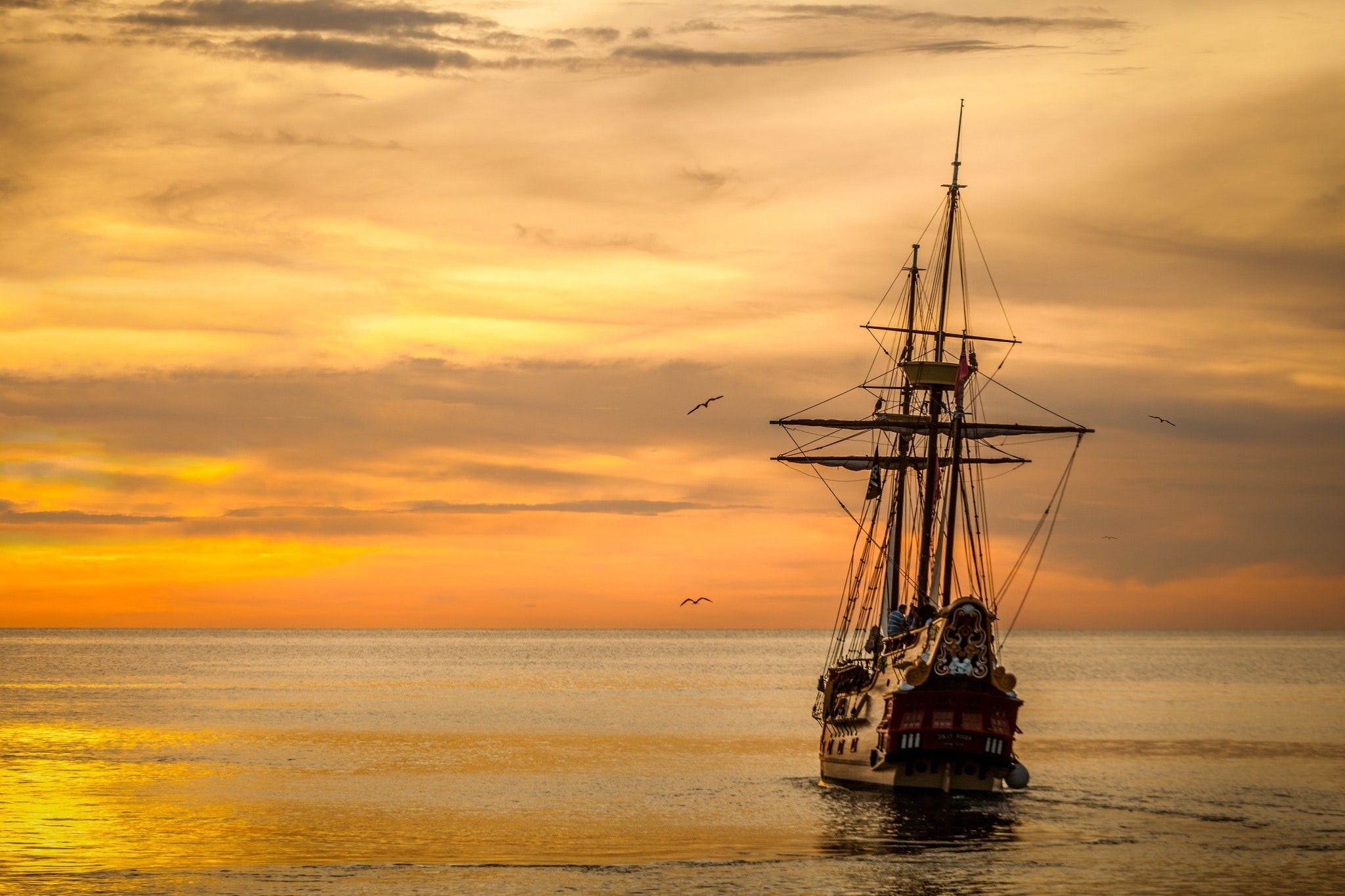 Brown sailing boat on the sea during sunset photo
