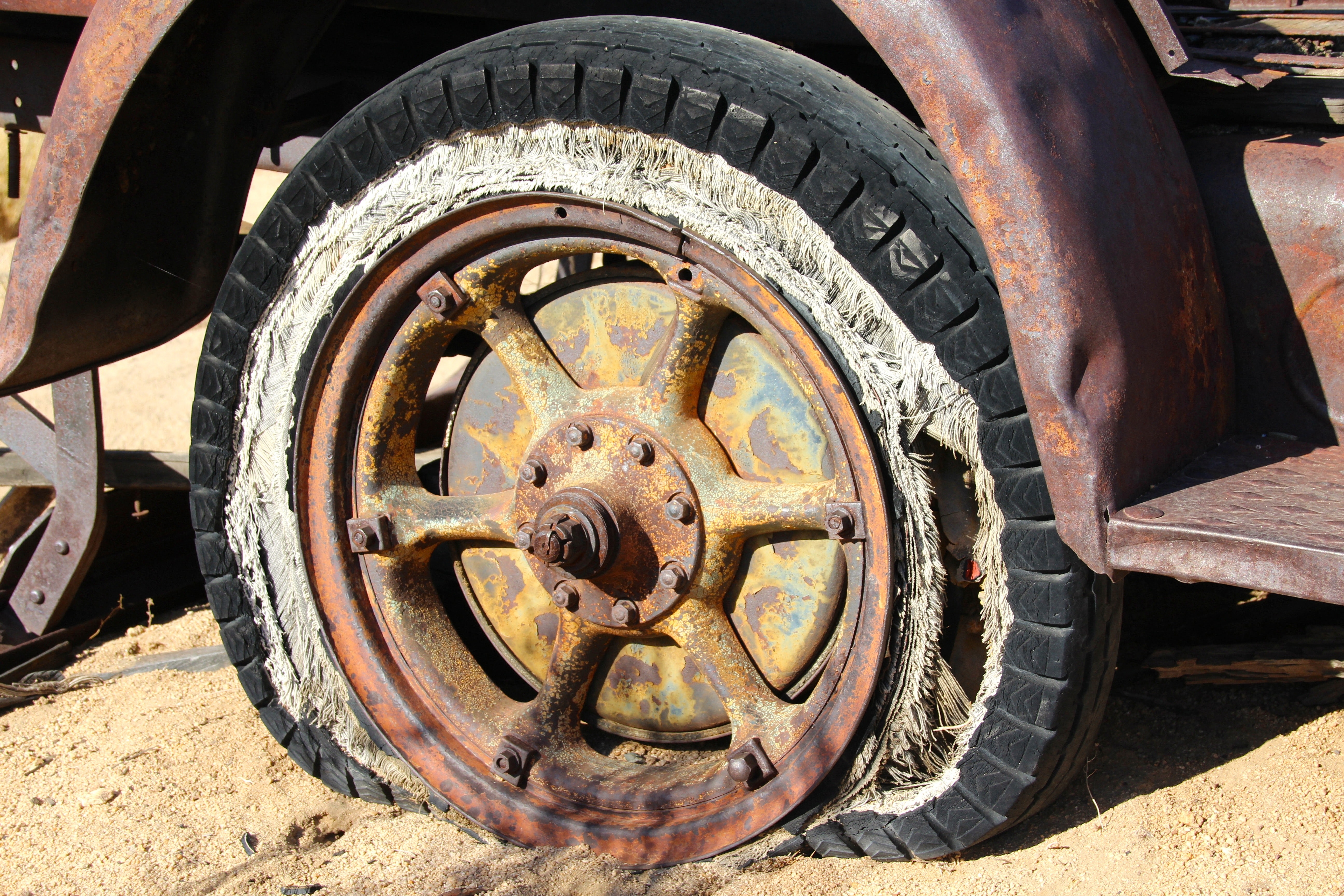 Brown spoke car wheel in brown sand during daytime photo