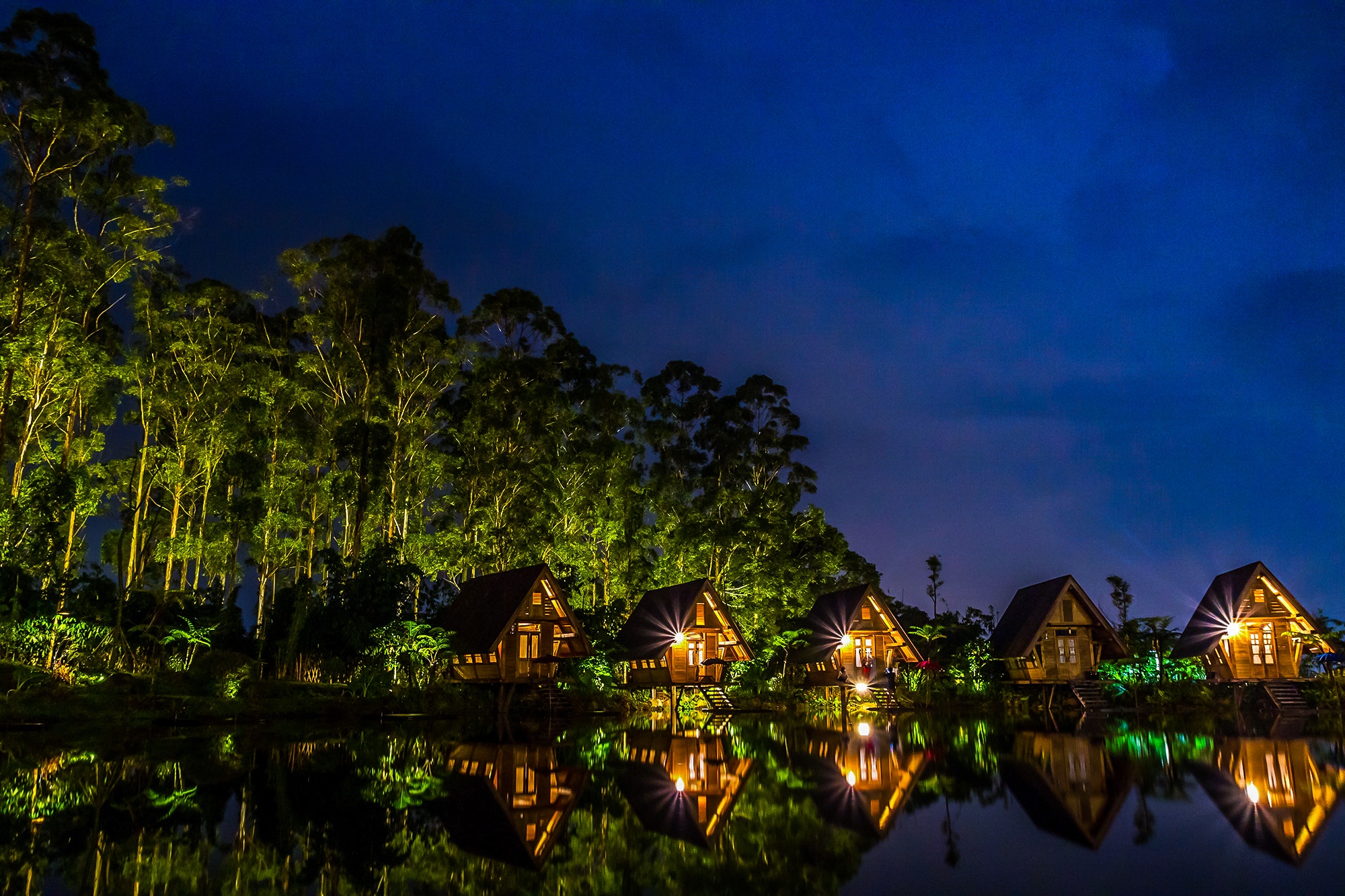 Brown wooden house near body of water during night time photo