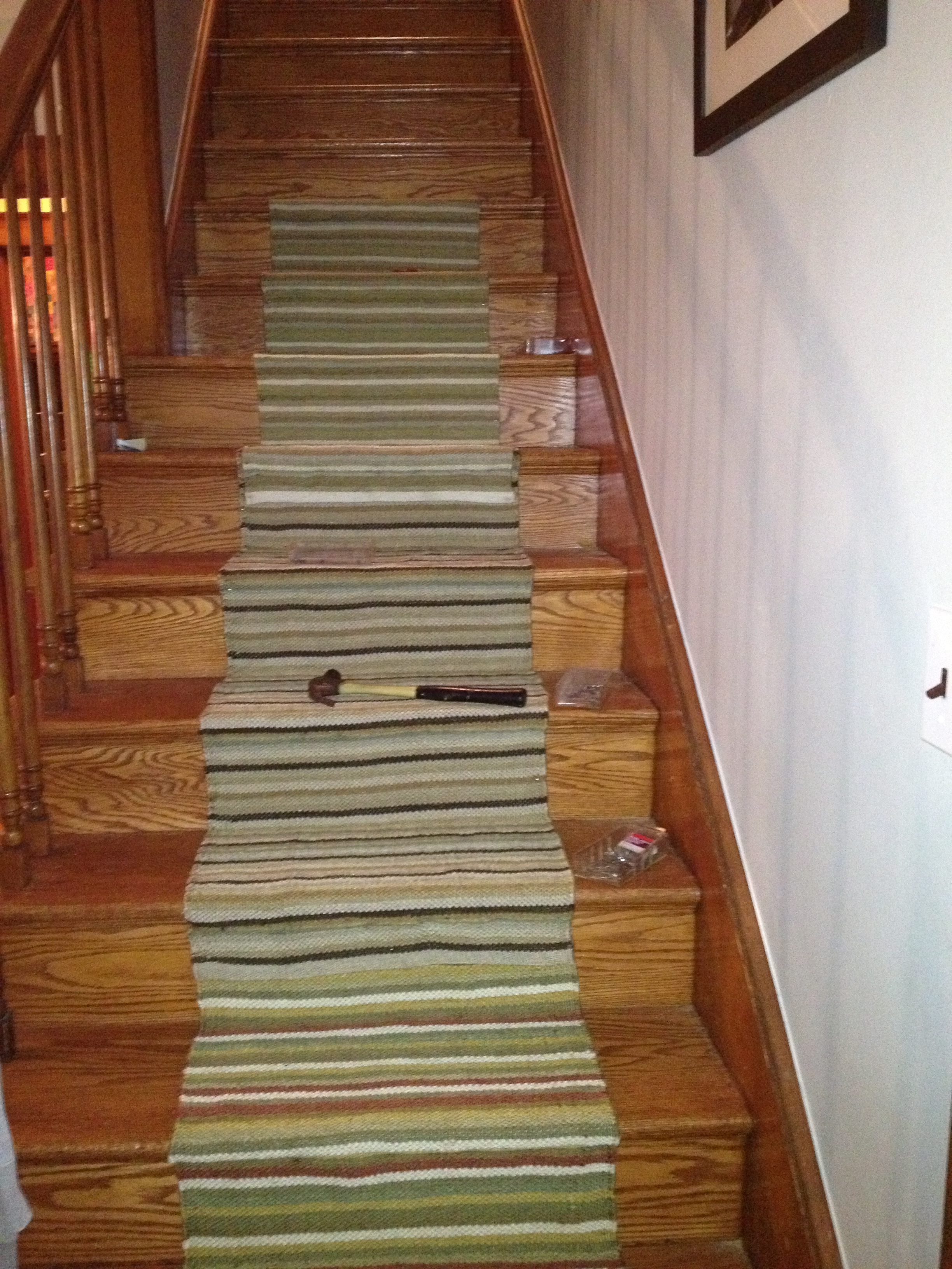 horizontal striped stairs Carpet on brown wooden staircase having ...