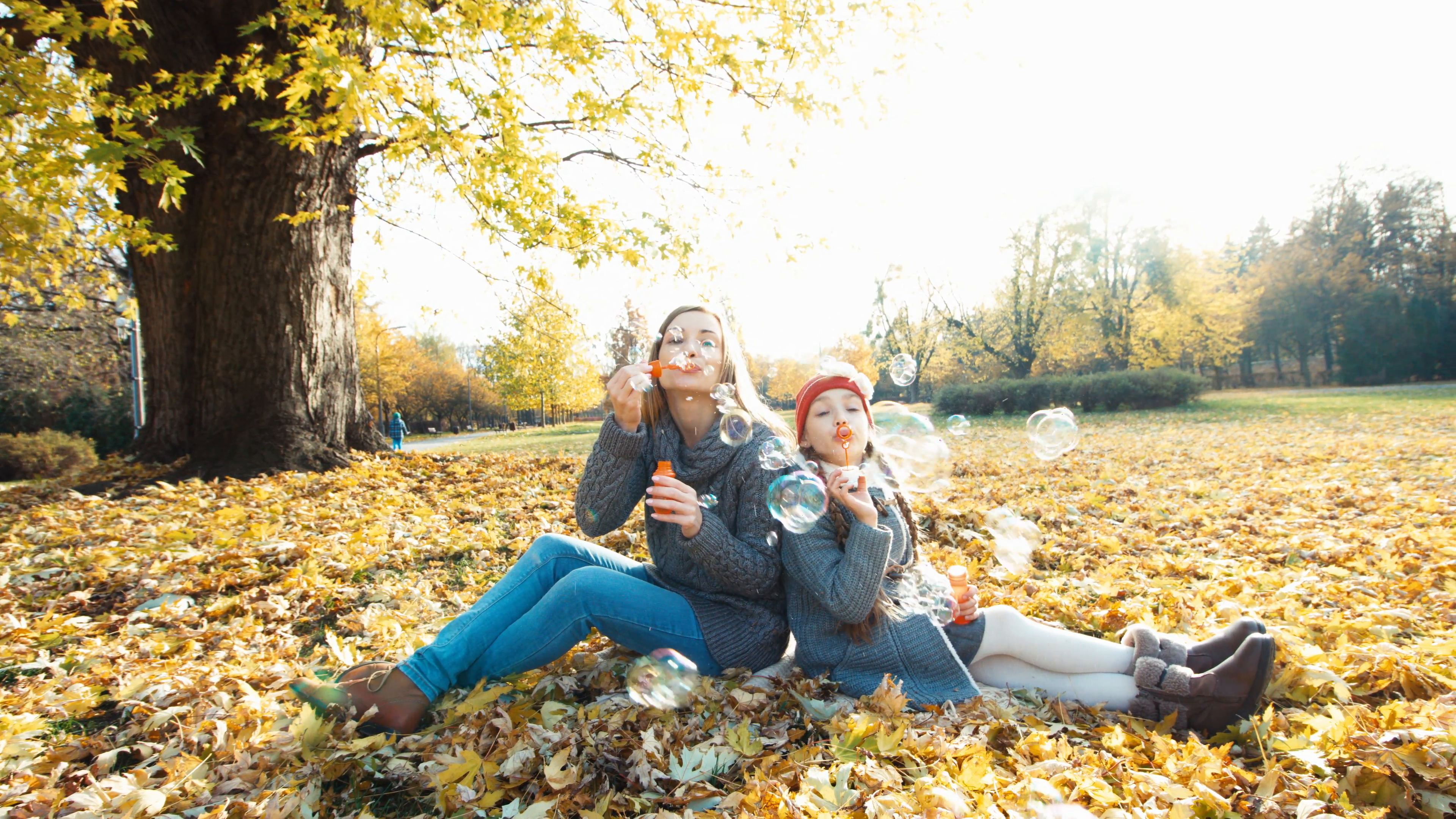 Autumn bubbles. Portrait mother and daughter blowing bubbles and ...