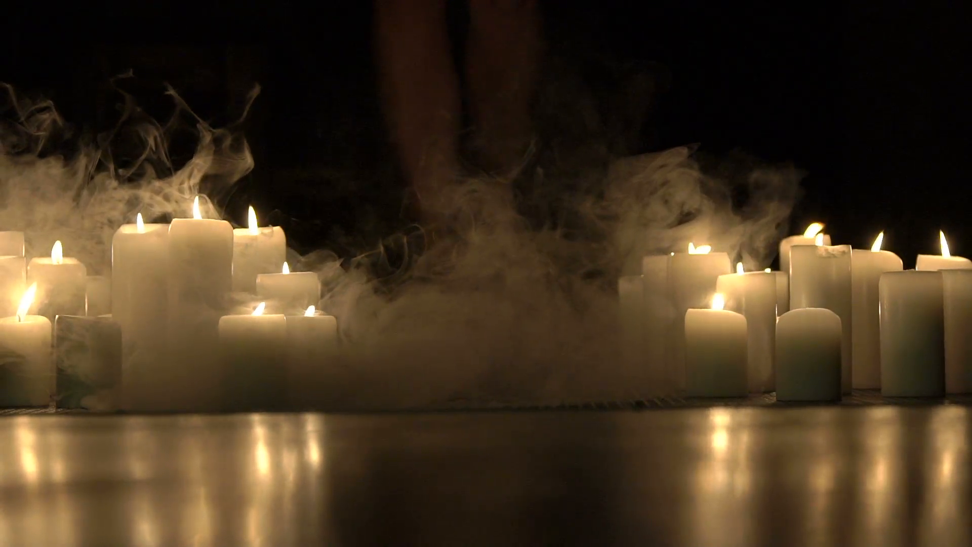 Girl's legs goes in big smoke of burning candles in darkness. Slowly ...