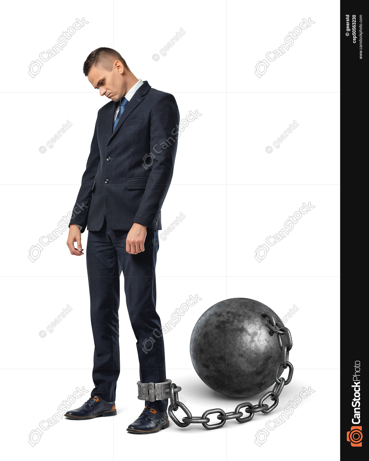 A sad businessman looks down while shackled to a large iron... stock ...