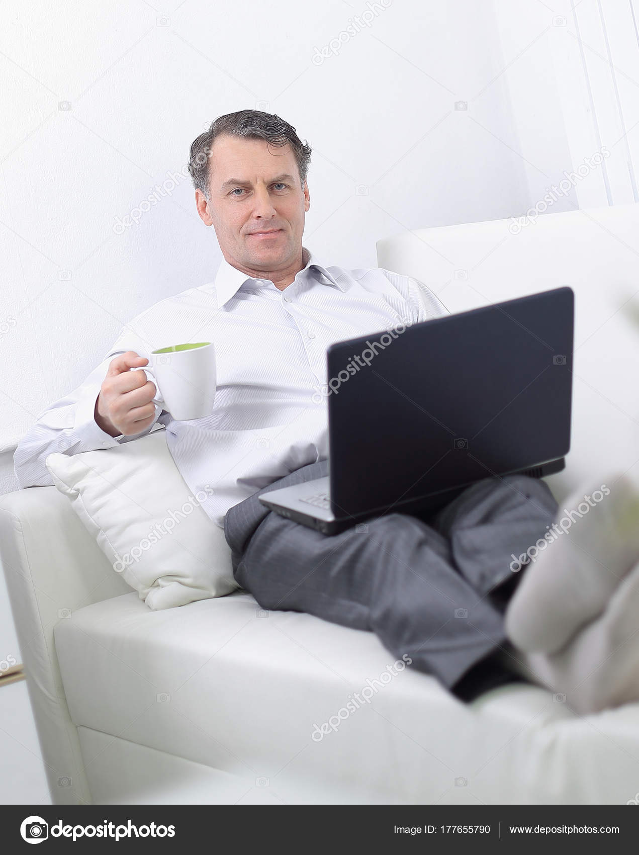 businessman drinking tea and working on laptop in the hotel room ...