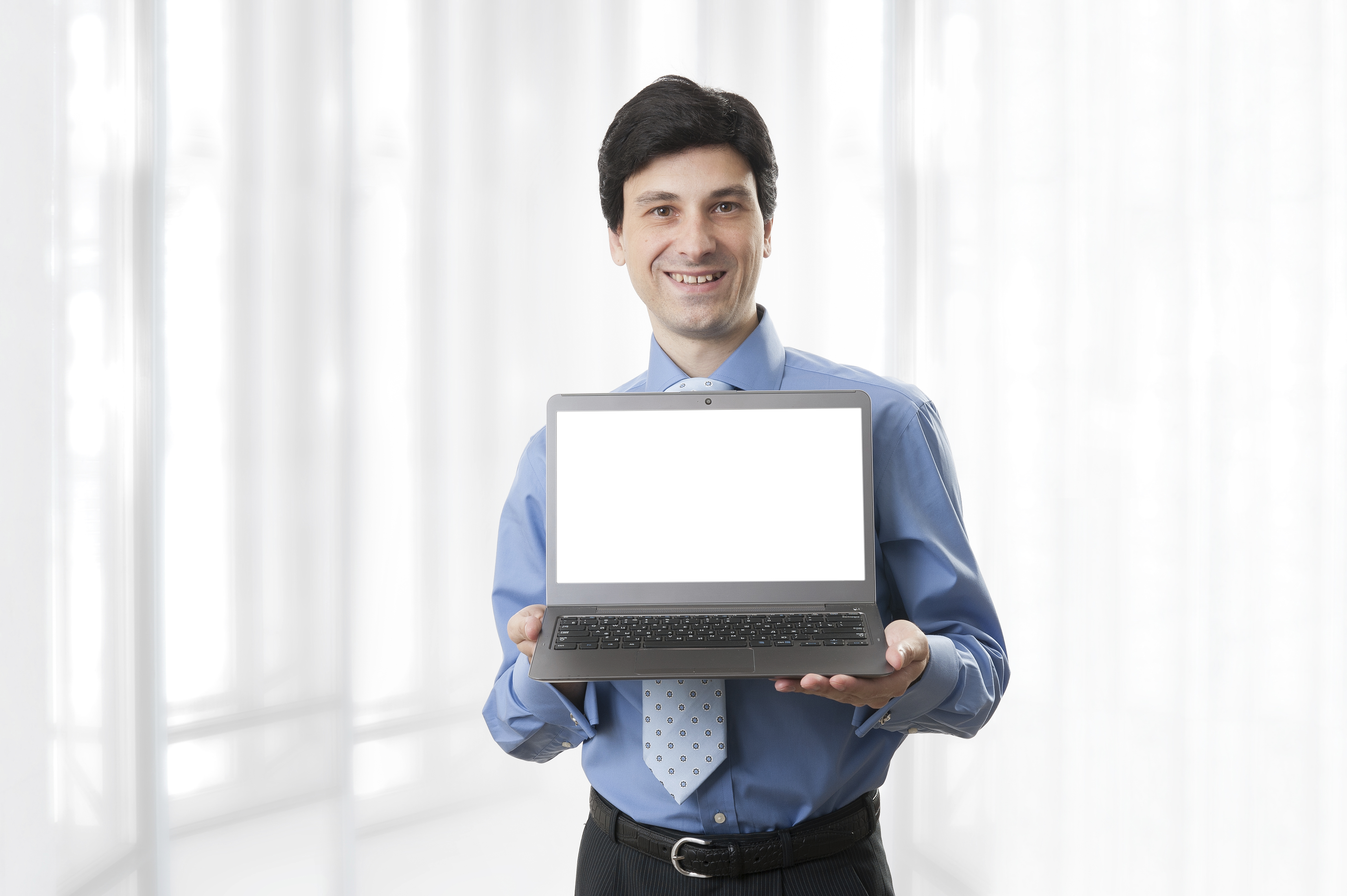 Businessman holding laptop | HuddleBoards.com