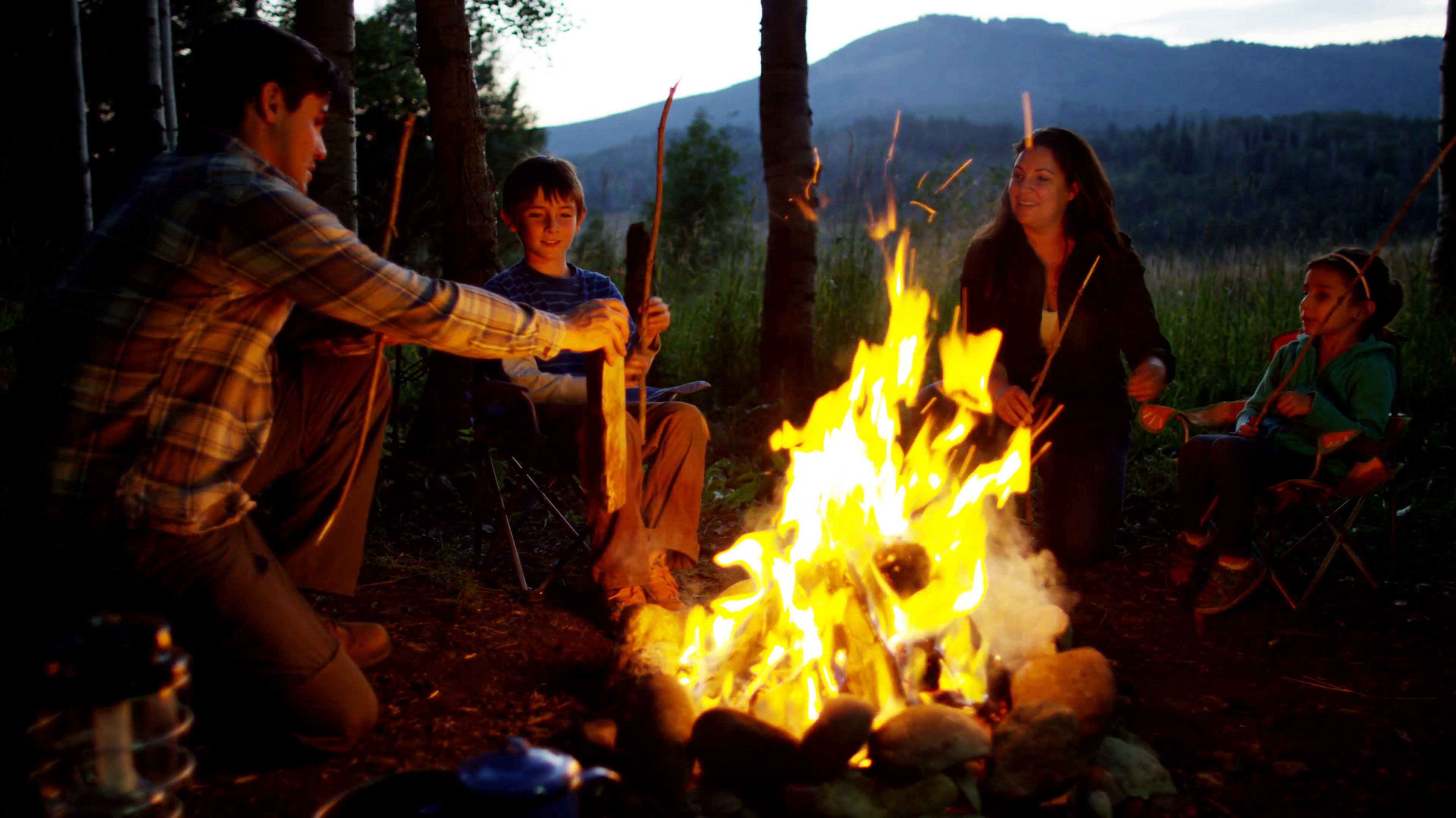 Happy American Caucasian family making campfire in nature on holiday ...