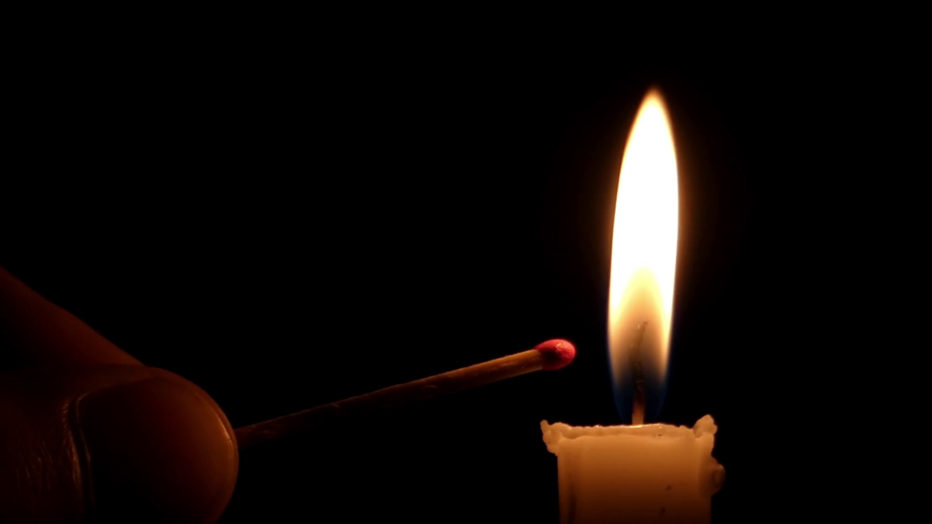 a Match Being Lit From a Thin Yellow Candle at Night. Stock Video ...