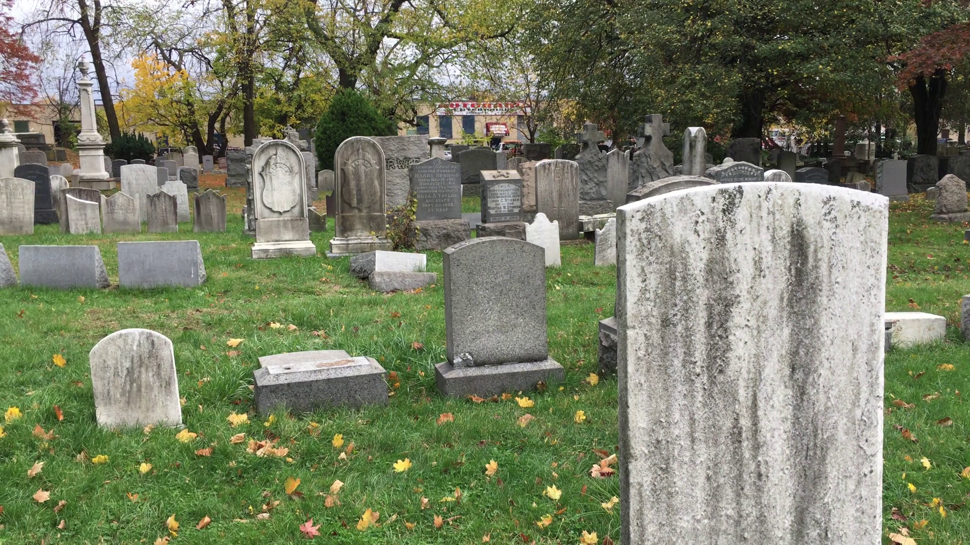 Sad man In city cemetery walks through graveyard to visit the grave ...