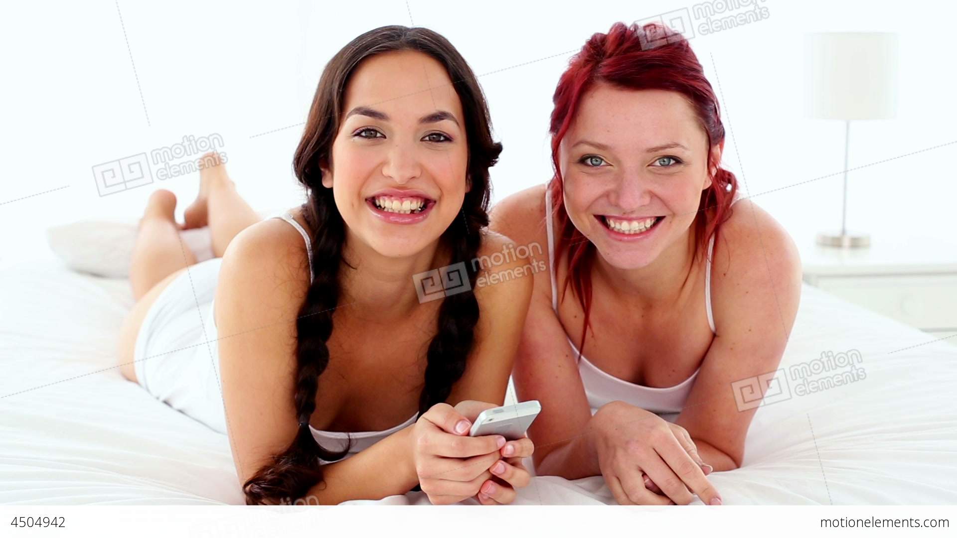 Cheerful Laughing Women Holding A Smartphone Lying Stock video ...