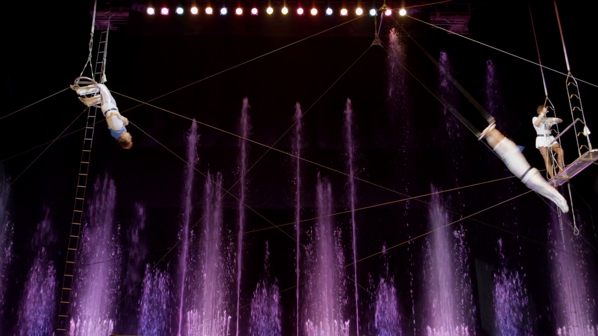 Aerial acrobatics perfomance in circus. Purple fountains in ...