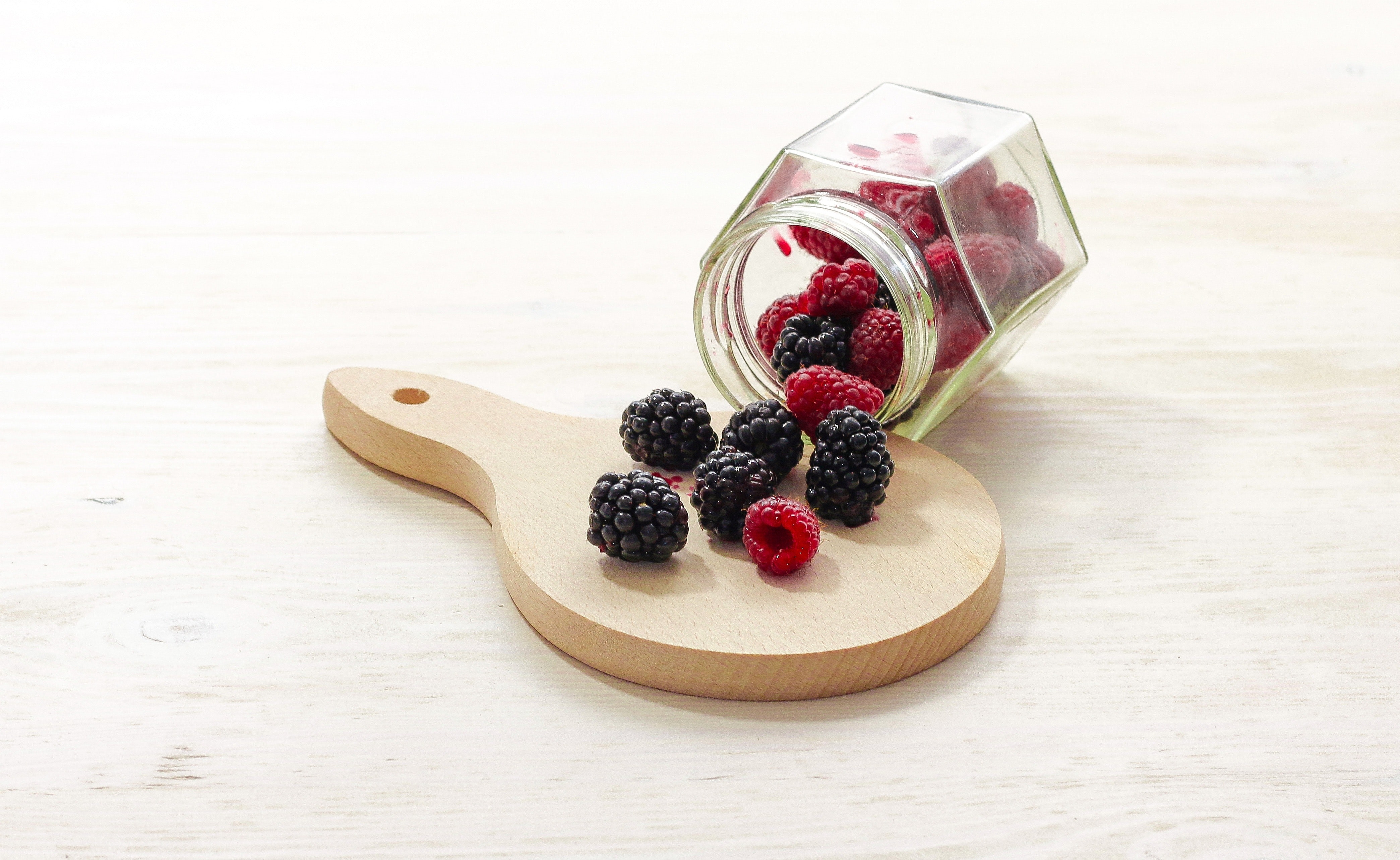 Clear glass bottle with raspberries inside photo
