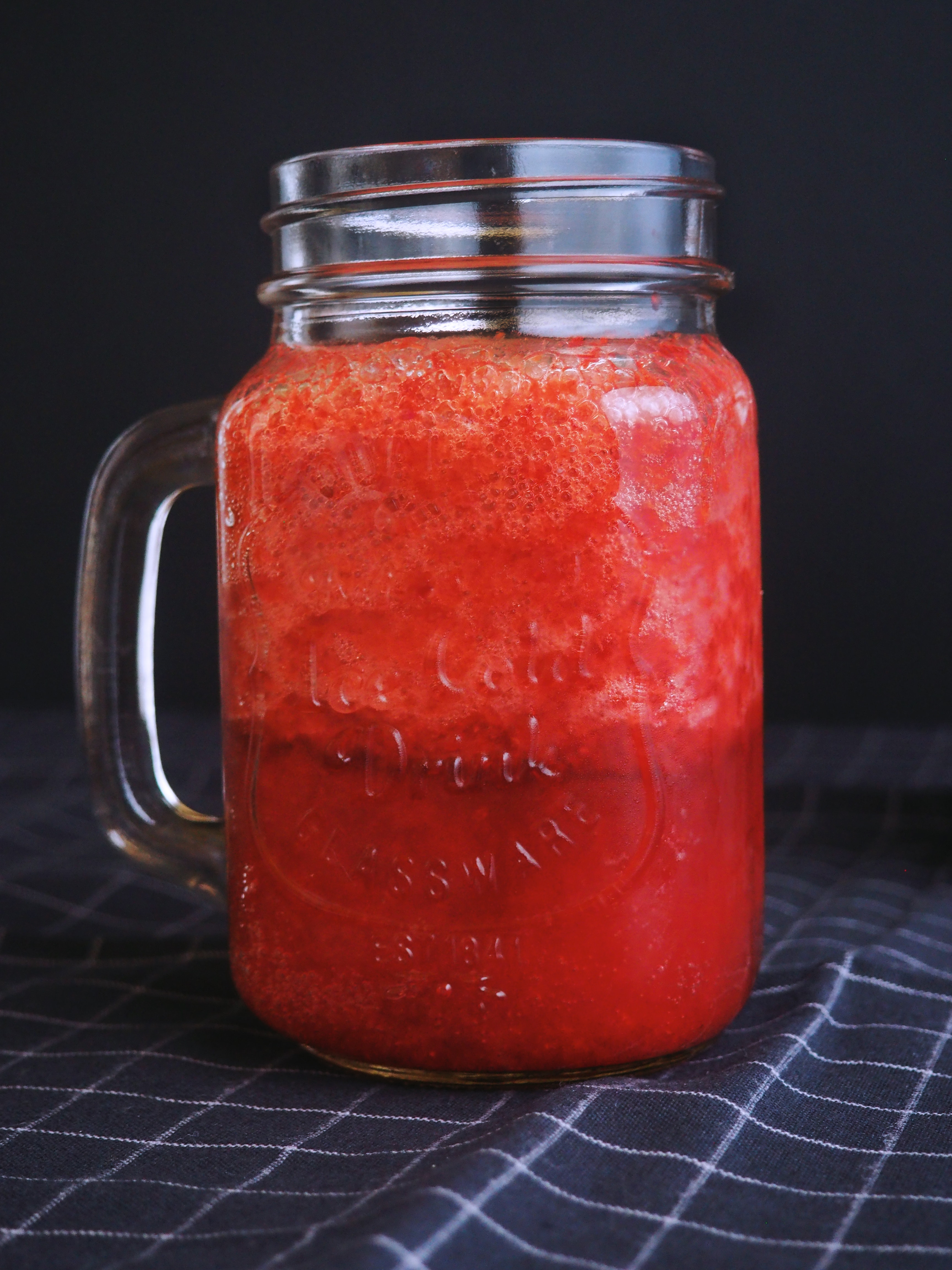 Clear glass mason mug filled with red liquid photo