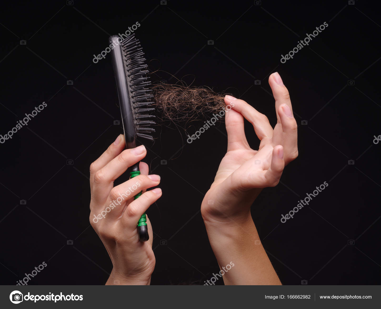 Close-up hands cleaning a comb from hair. Girl and hairbrush on the ...