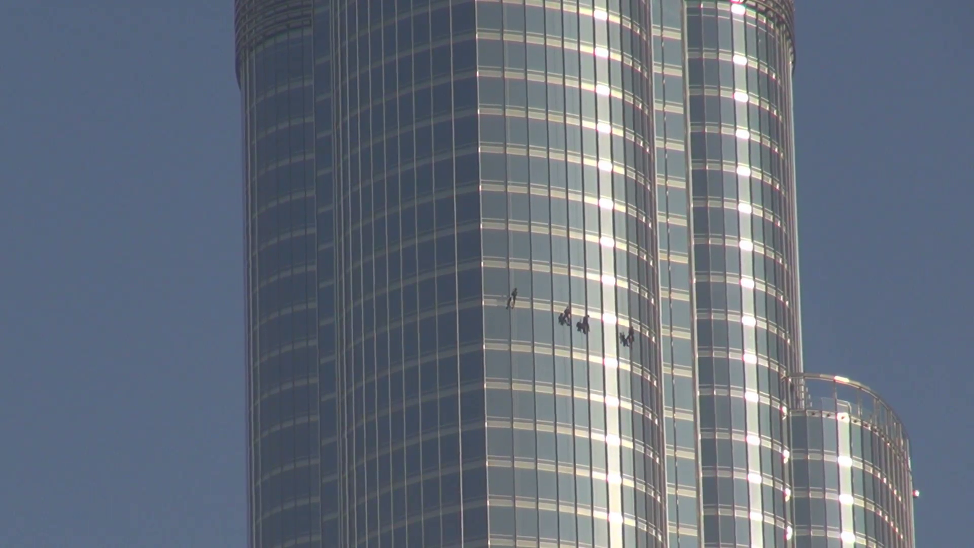 Closeup climber man wash glasses facade Burj Khalifa tower building ...