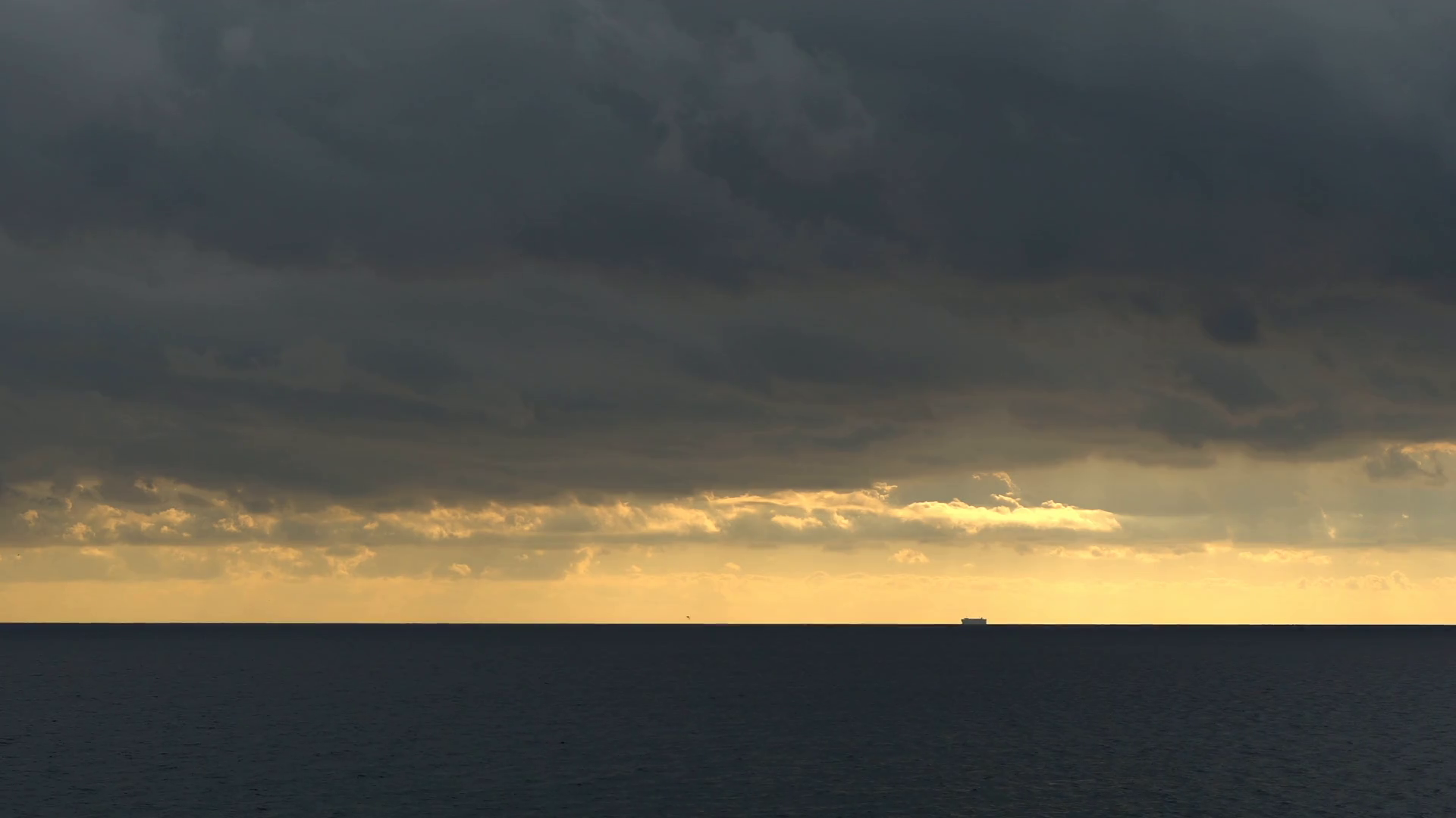 Cloudy evening at the seaside with a large ship far away over the ...