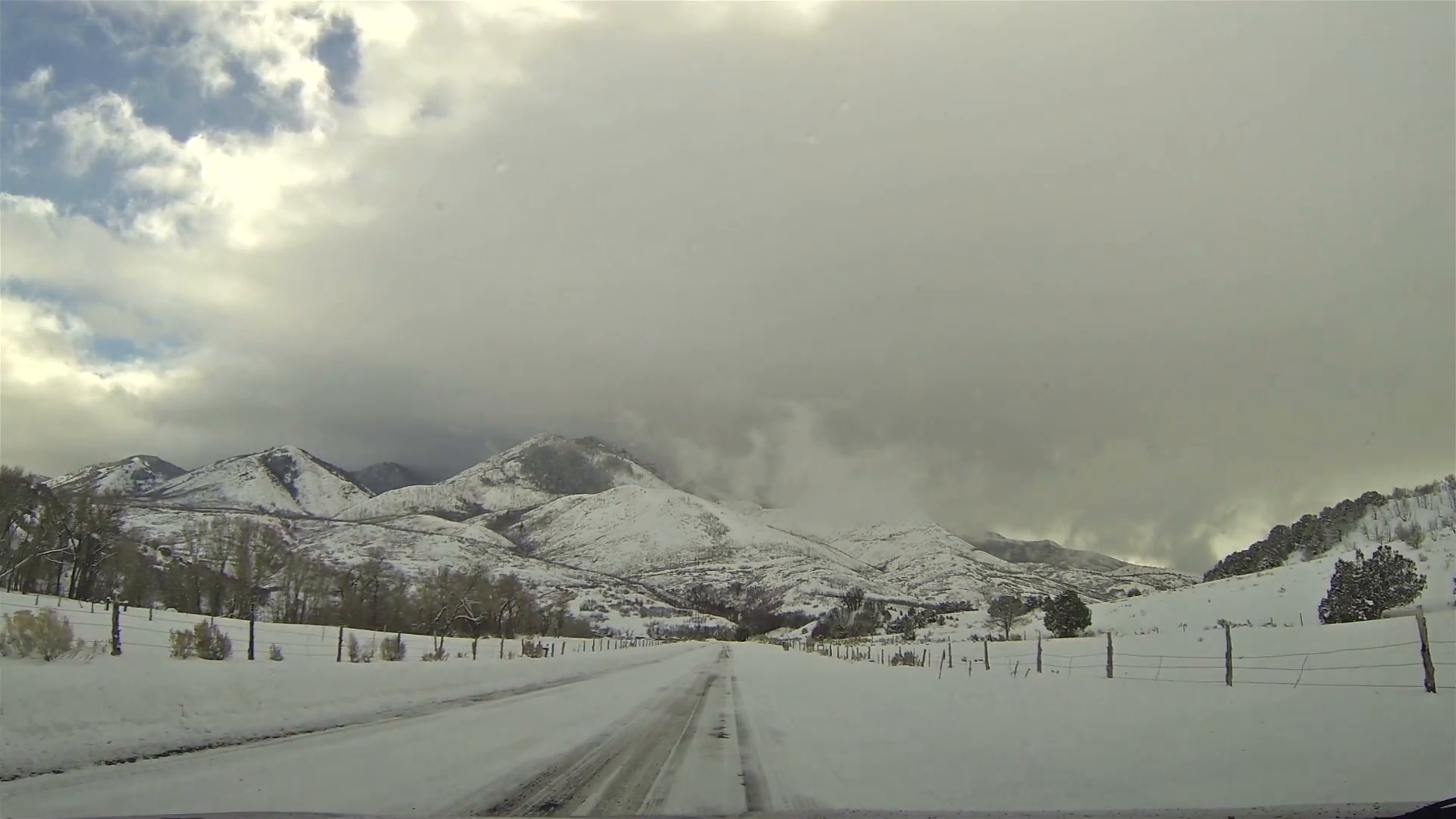 Winter snowy and cloudy day mountain road. Driving a car on rural ...
