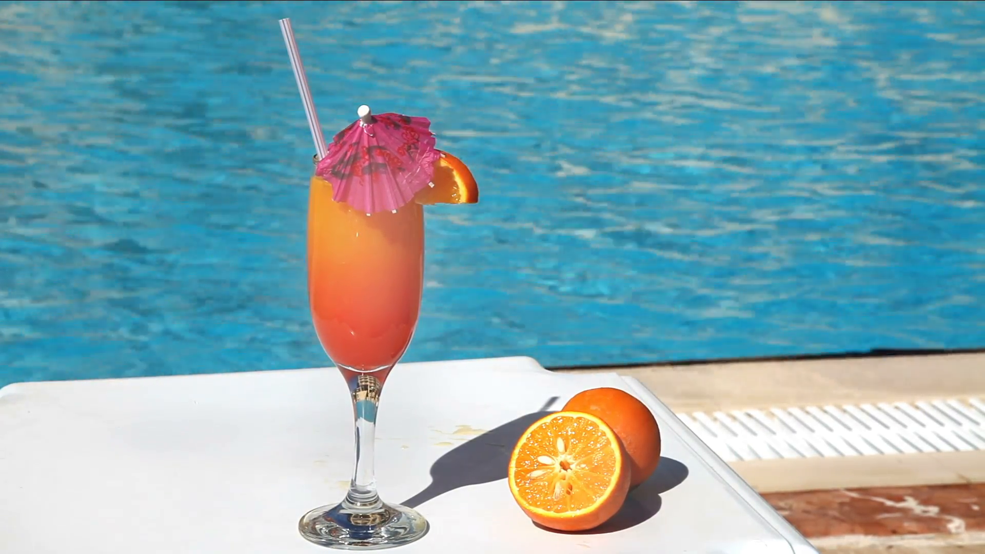 Orange cocktail with umbrella and straw near swimming pool Stock ...