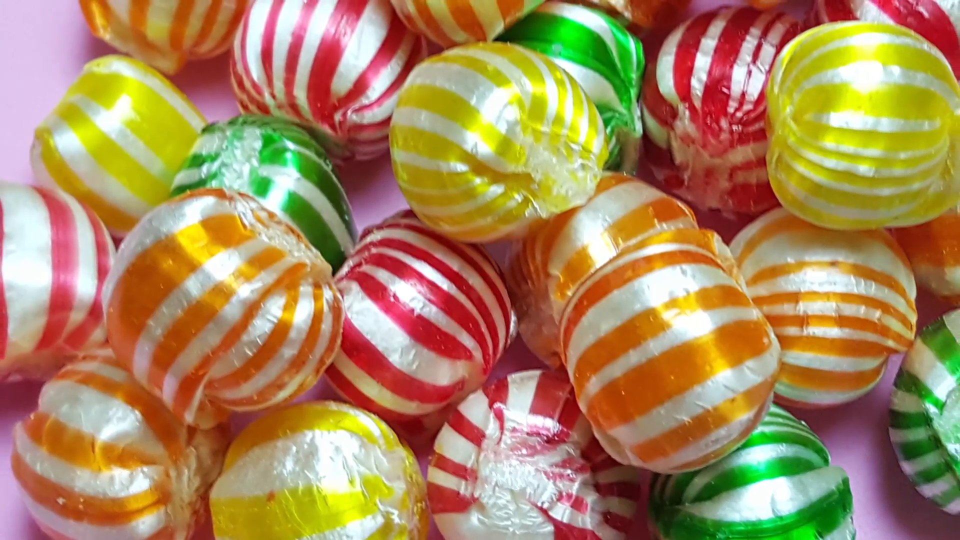 Colorful candies on pink background Stock Video Footage - Videoblocks
