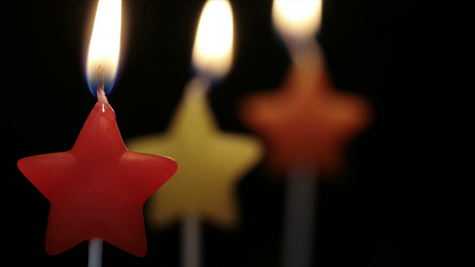 Close up of three colorful star shaped candles burning. Stock Video ...