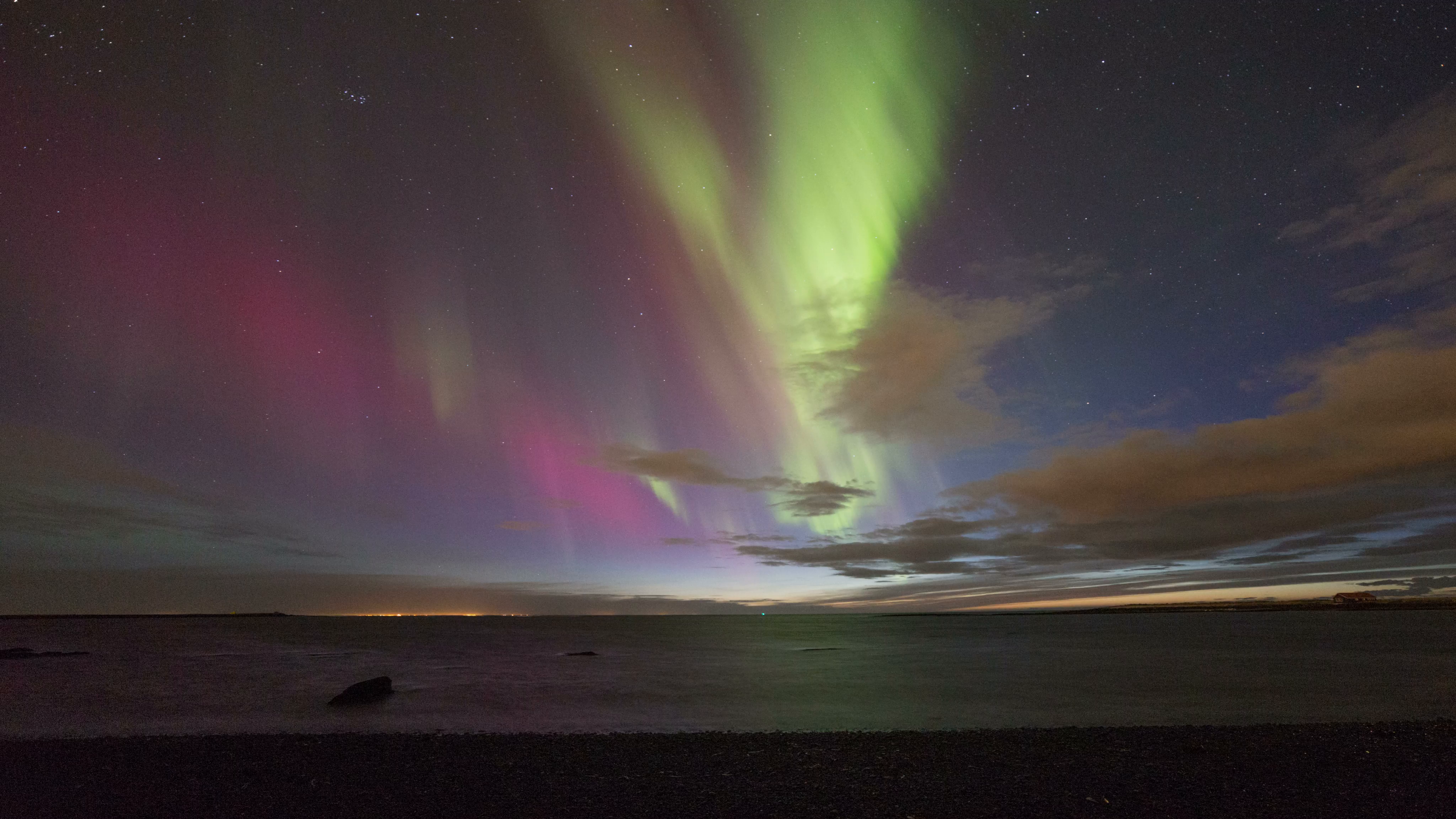 Colorful active aurora (northern lights) over the ocean at sunset in ...