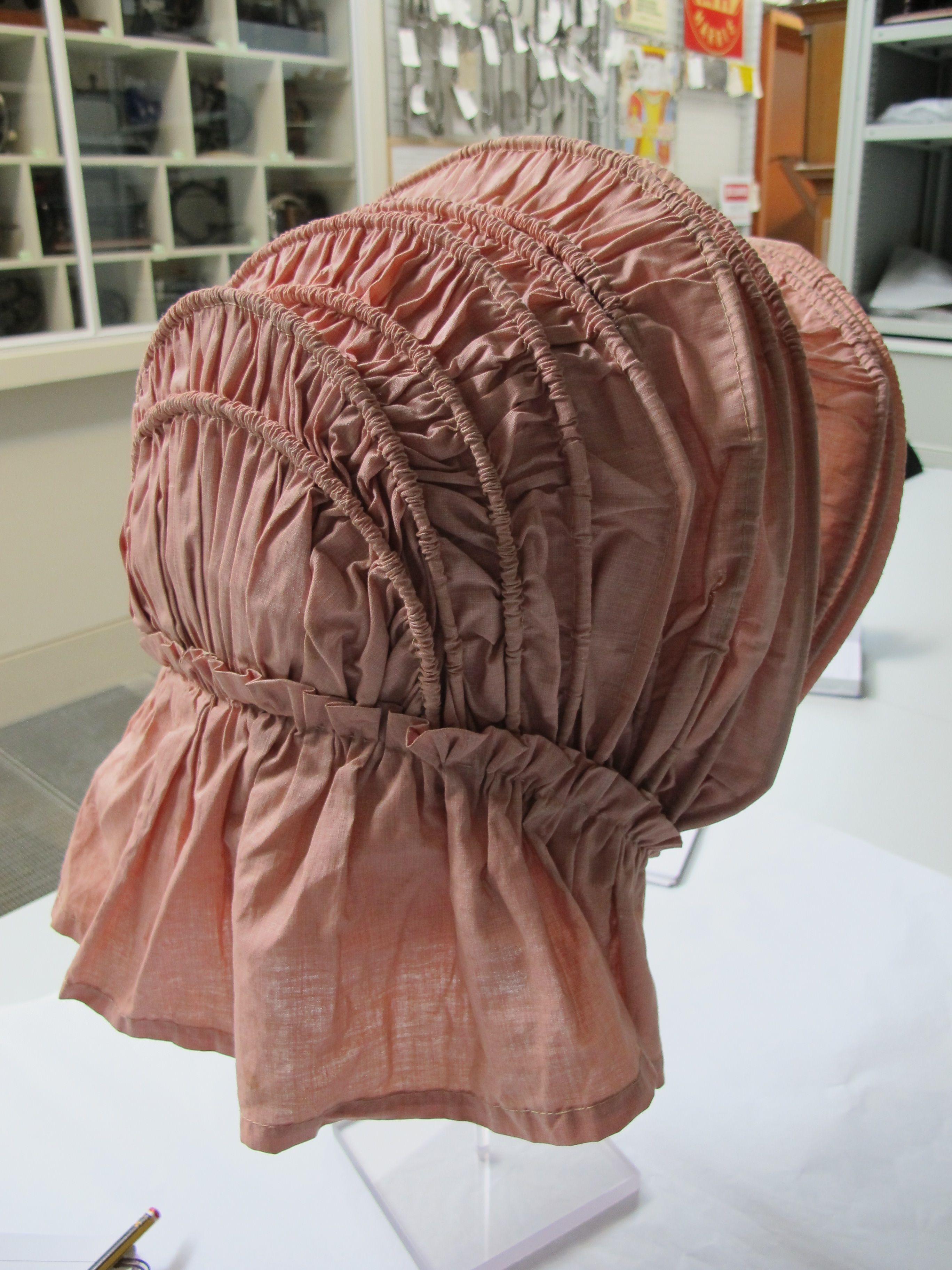 19th-century pink-and-white self-checked cotton bonnet, with an ...