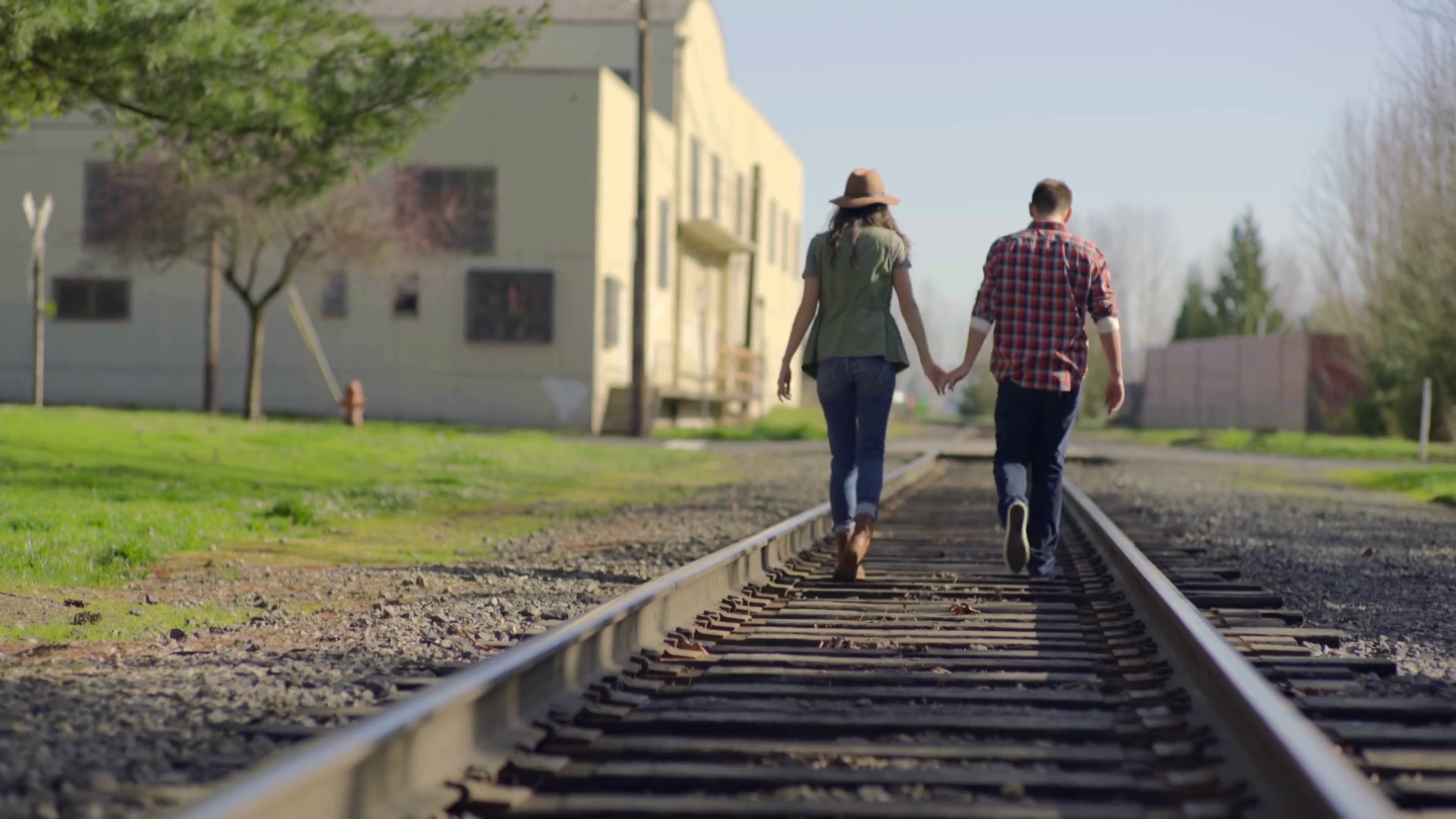 Couple Dance Along Train Tracks, Camera Tilts Up As They Walk Down ...