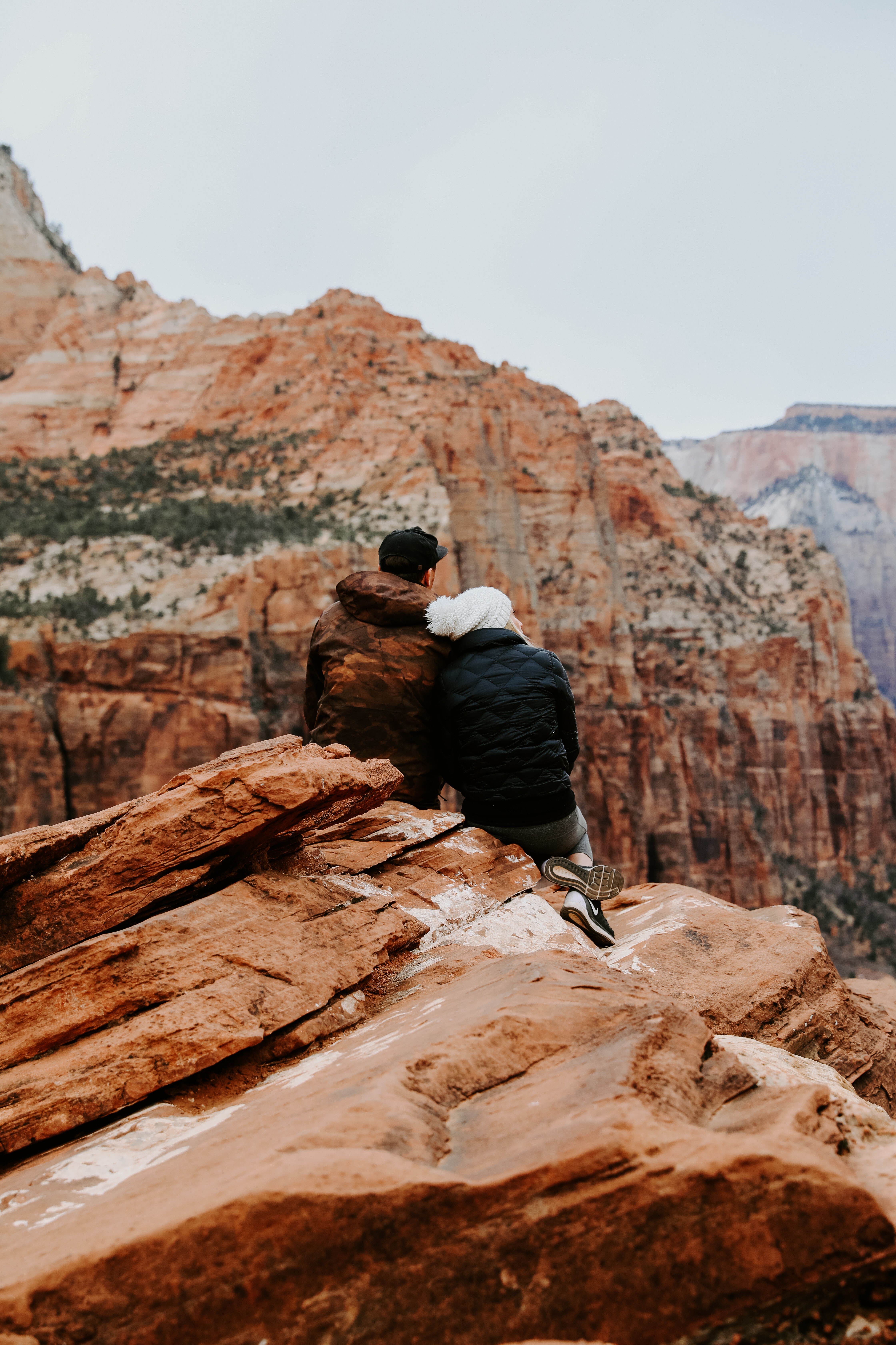 Couple sitting on rock cliff photo