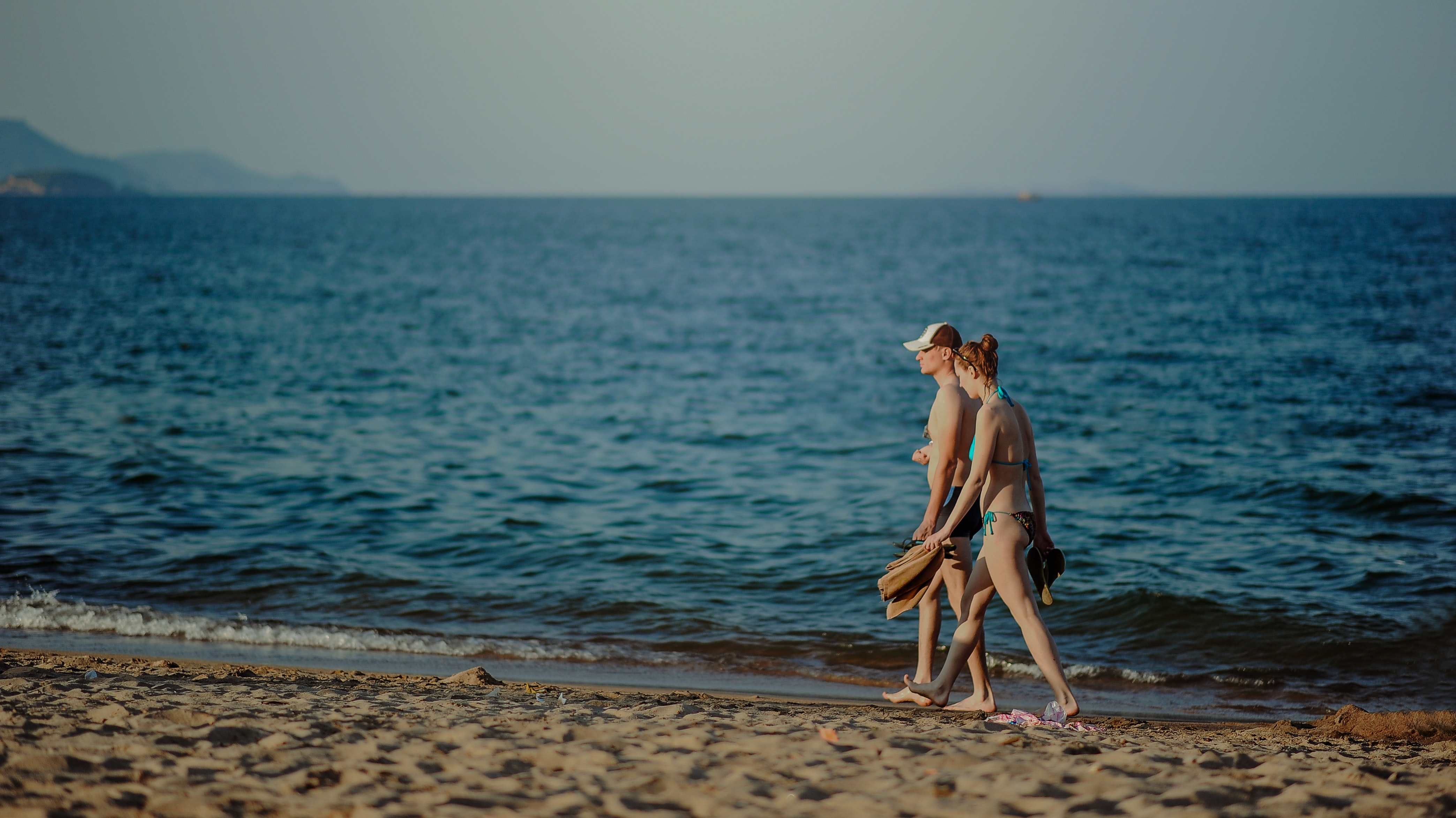 Couple walking on the beach at daytime photo