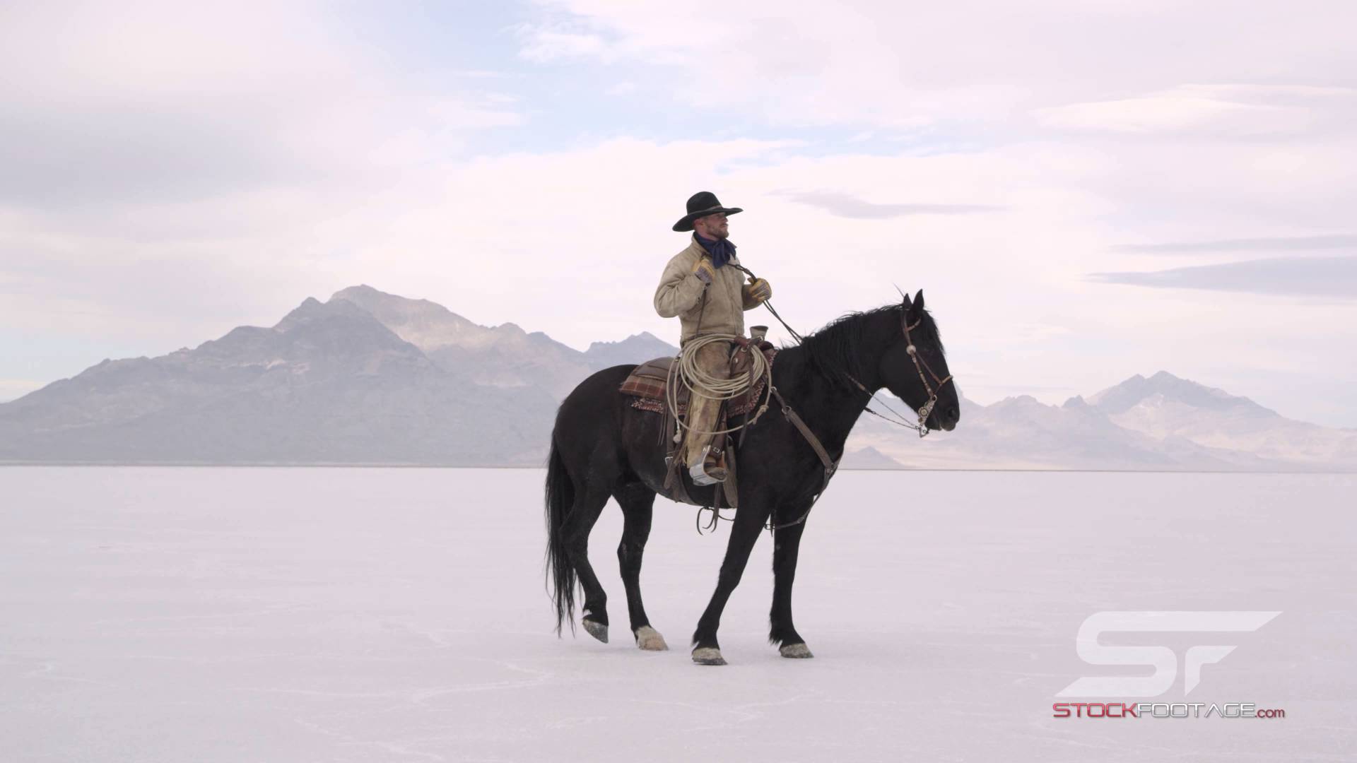 Cowboy riding horse in slow motion on salt flats in 4K Ultra HD ...