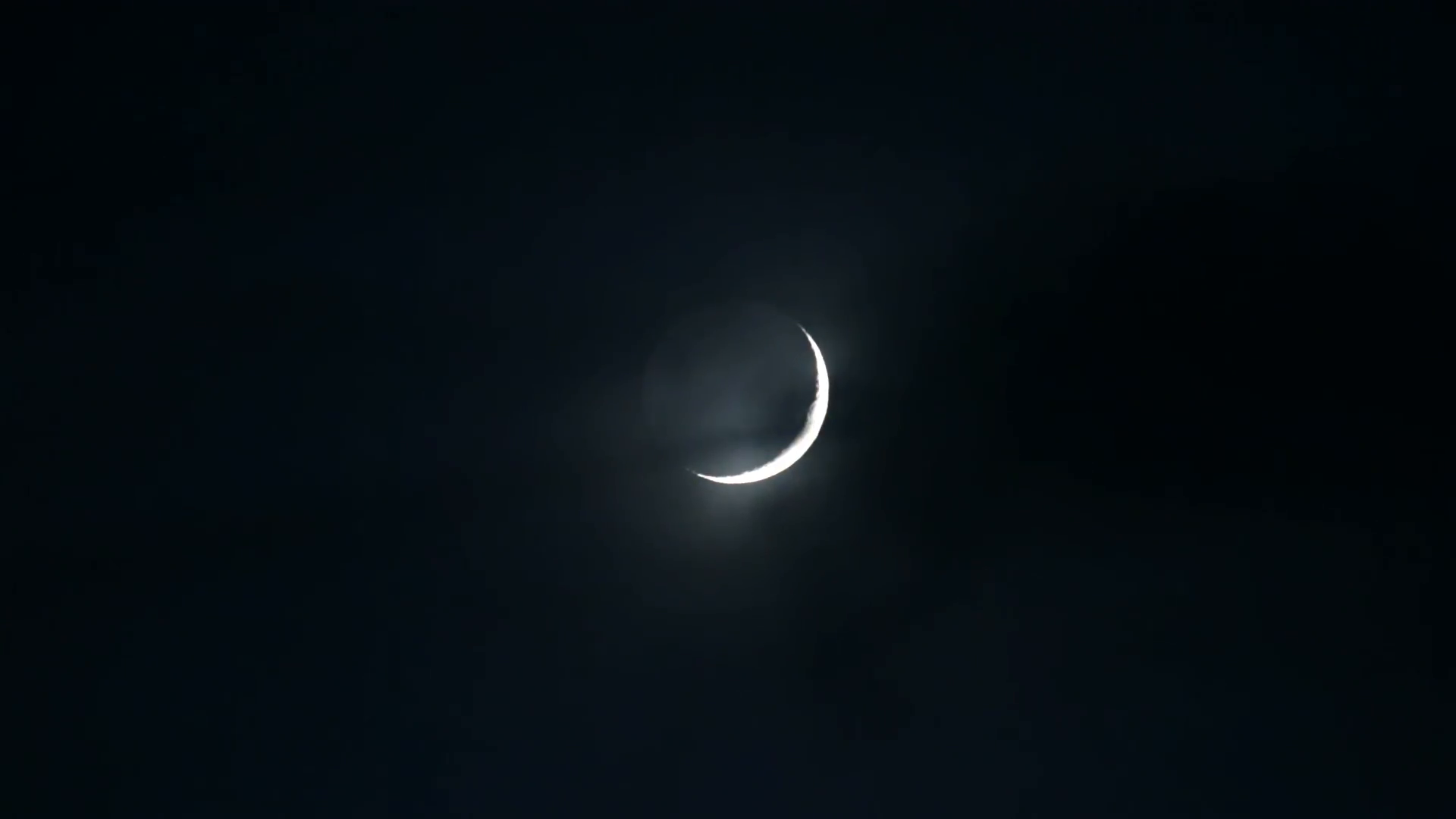 Thin crescent moon behind whispy clouds dark sky Stock Video Footage ...