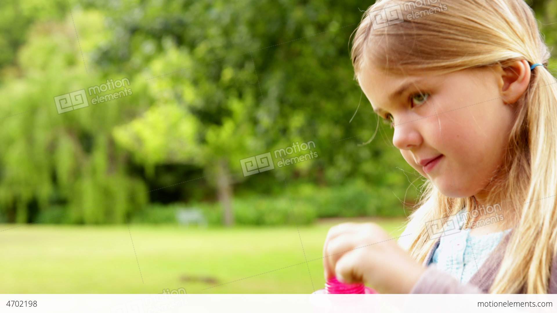 Cute Little Girl Blowing Bubbles In Park Stock video footage | 4702198