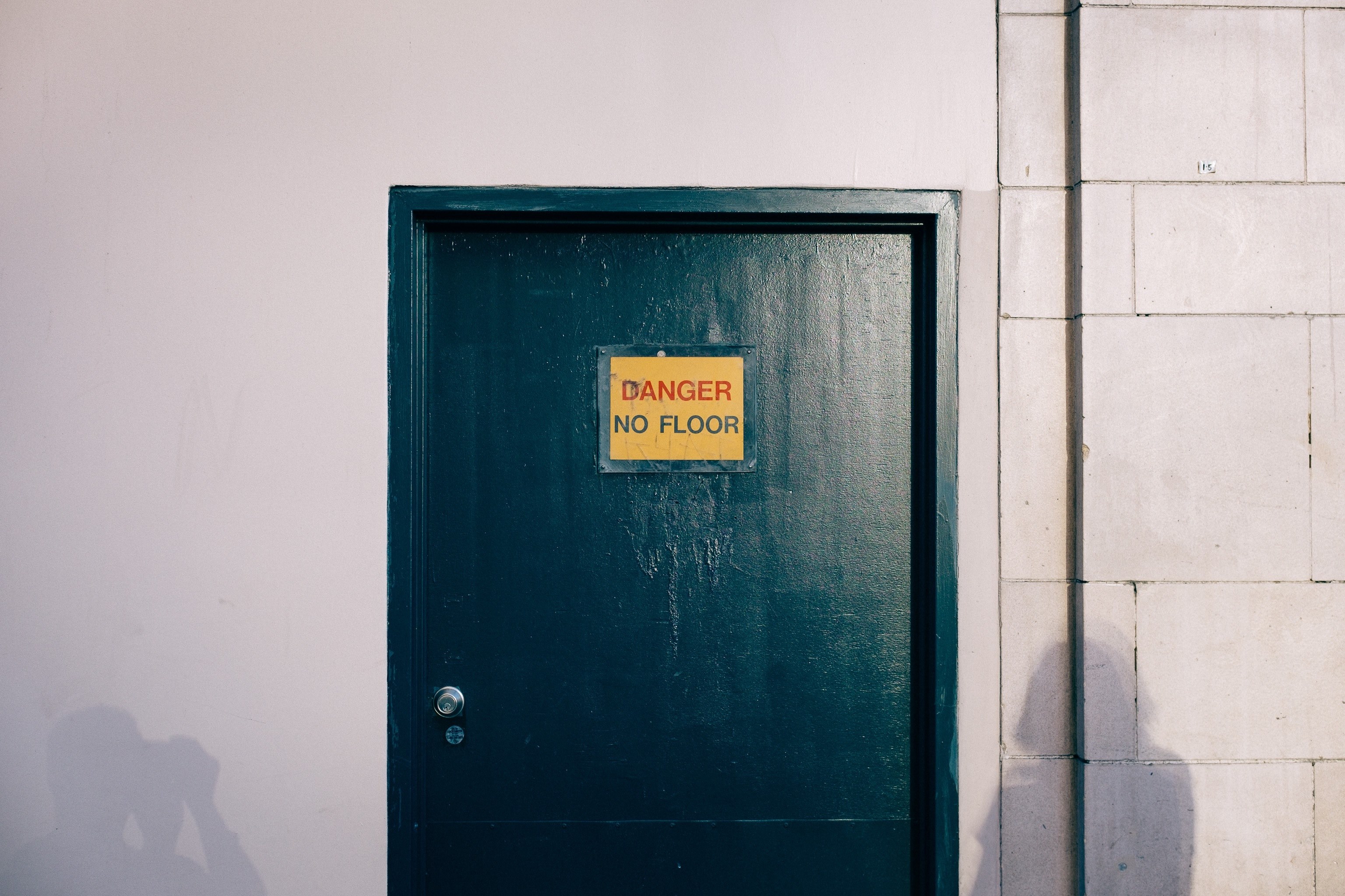 a black door with a yellow sign that reads danger no floor black ...
