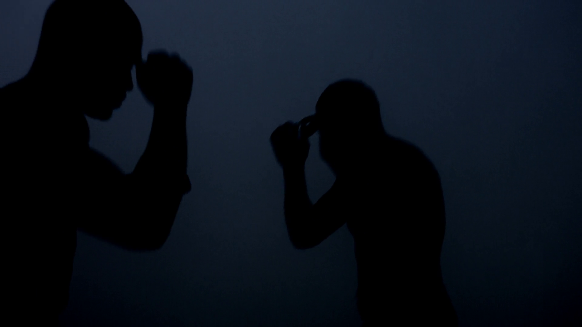 Silhouettes kick boxers fight in dark. Closeup of mma fighter ...