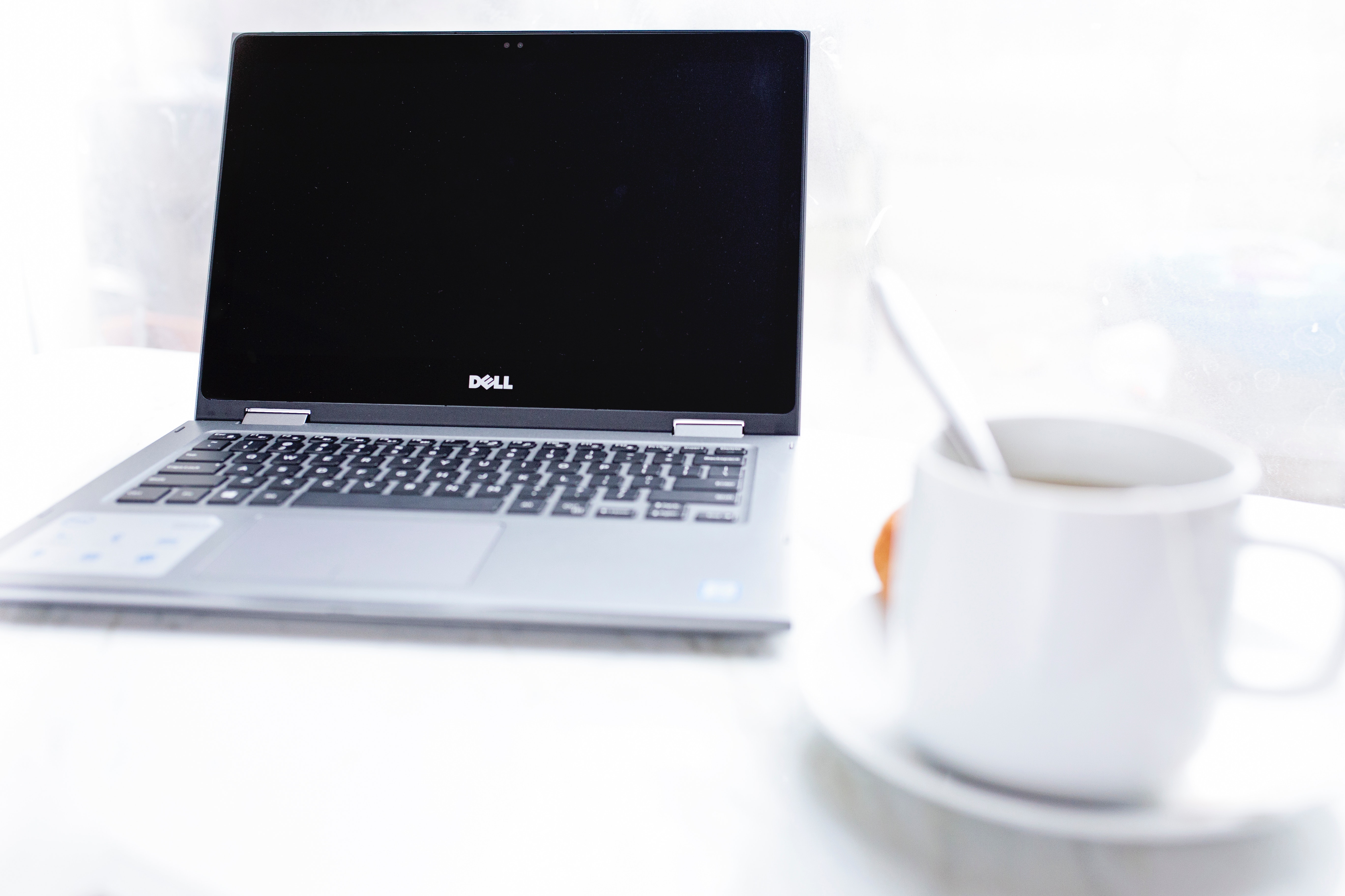 Dell laptop in front of cup of coffee photo