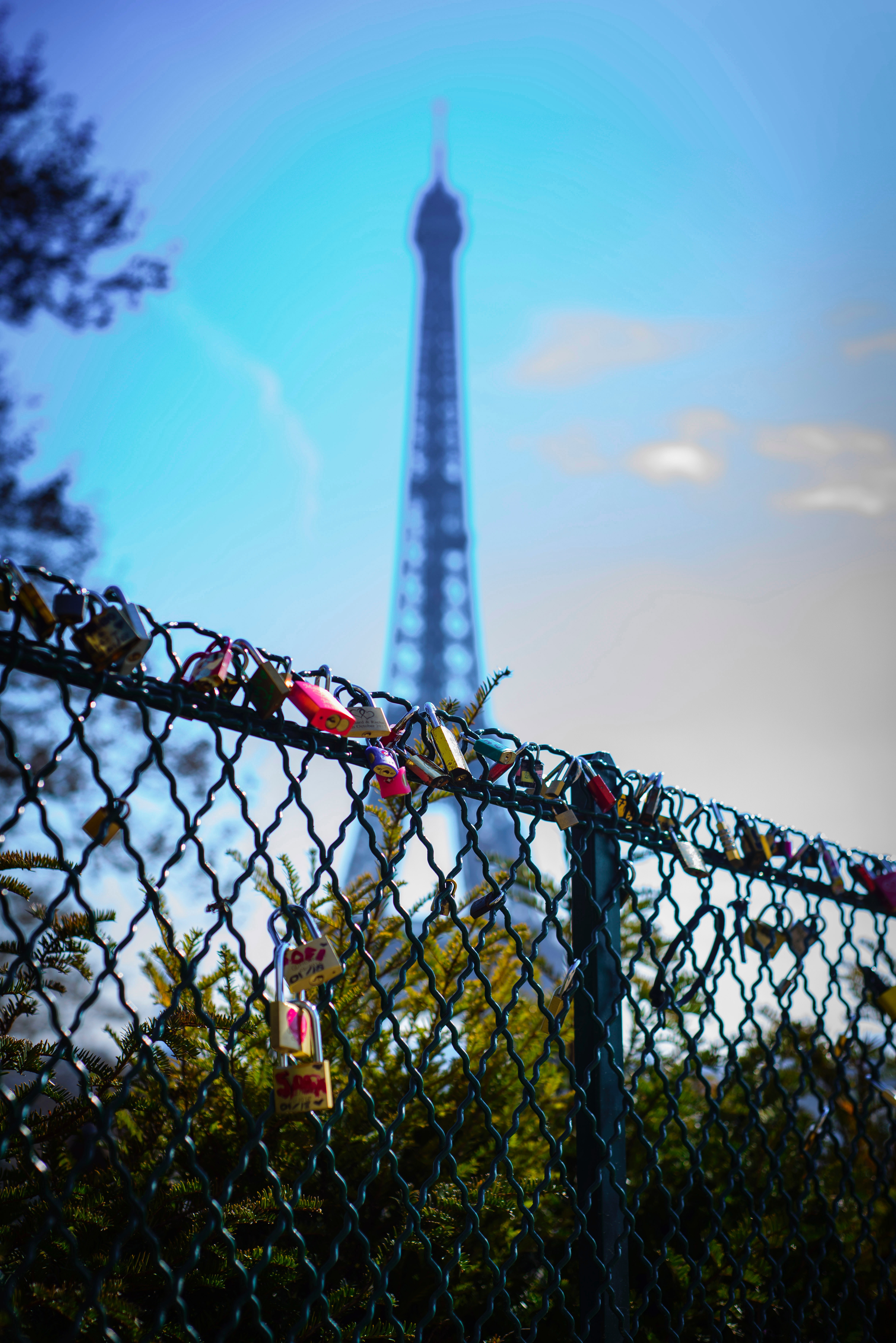 Depth of field photography of love keys on chain link fence in front of eiffel tower