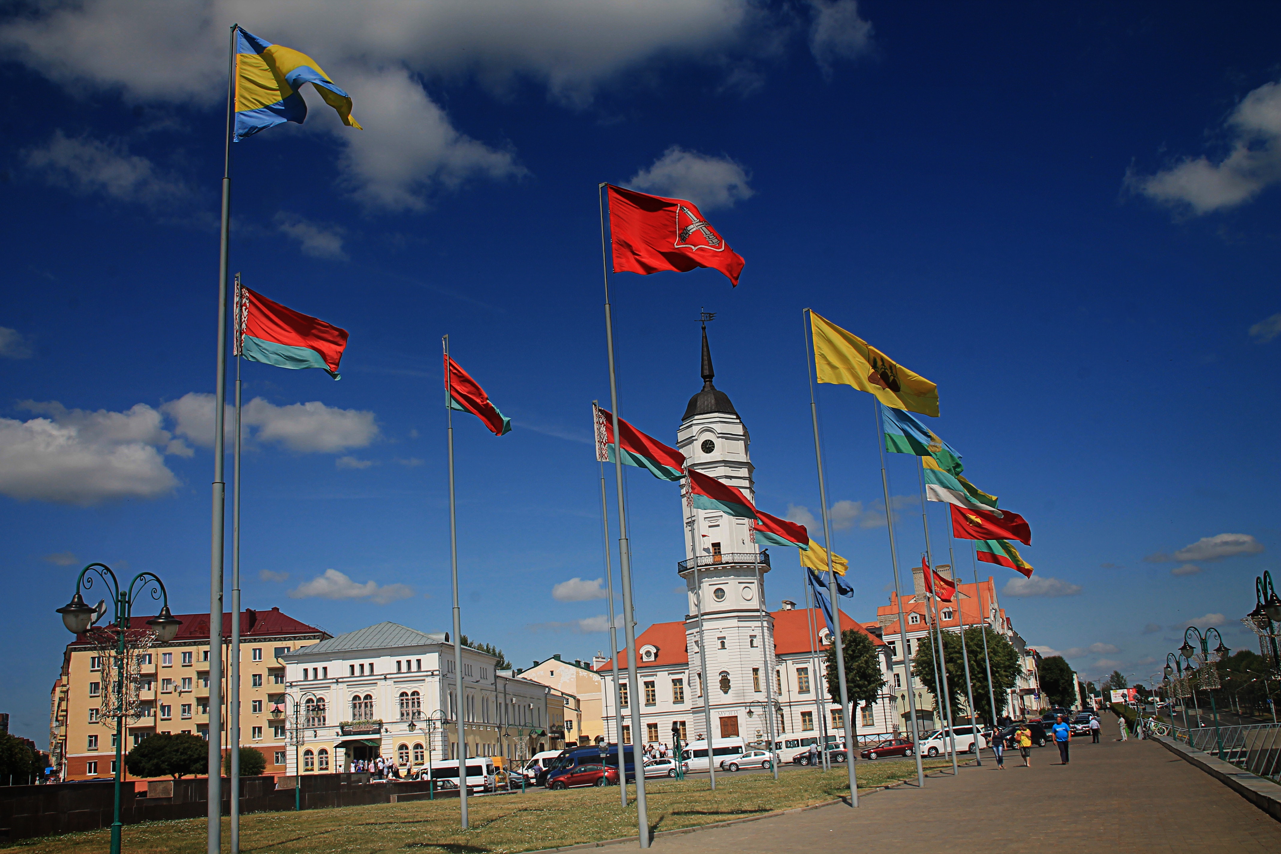 Different flags waving on poles at daytime photo