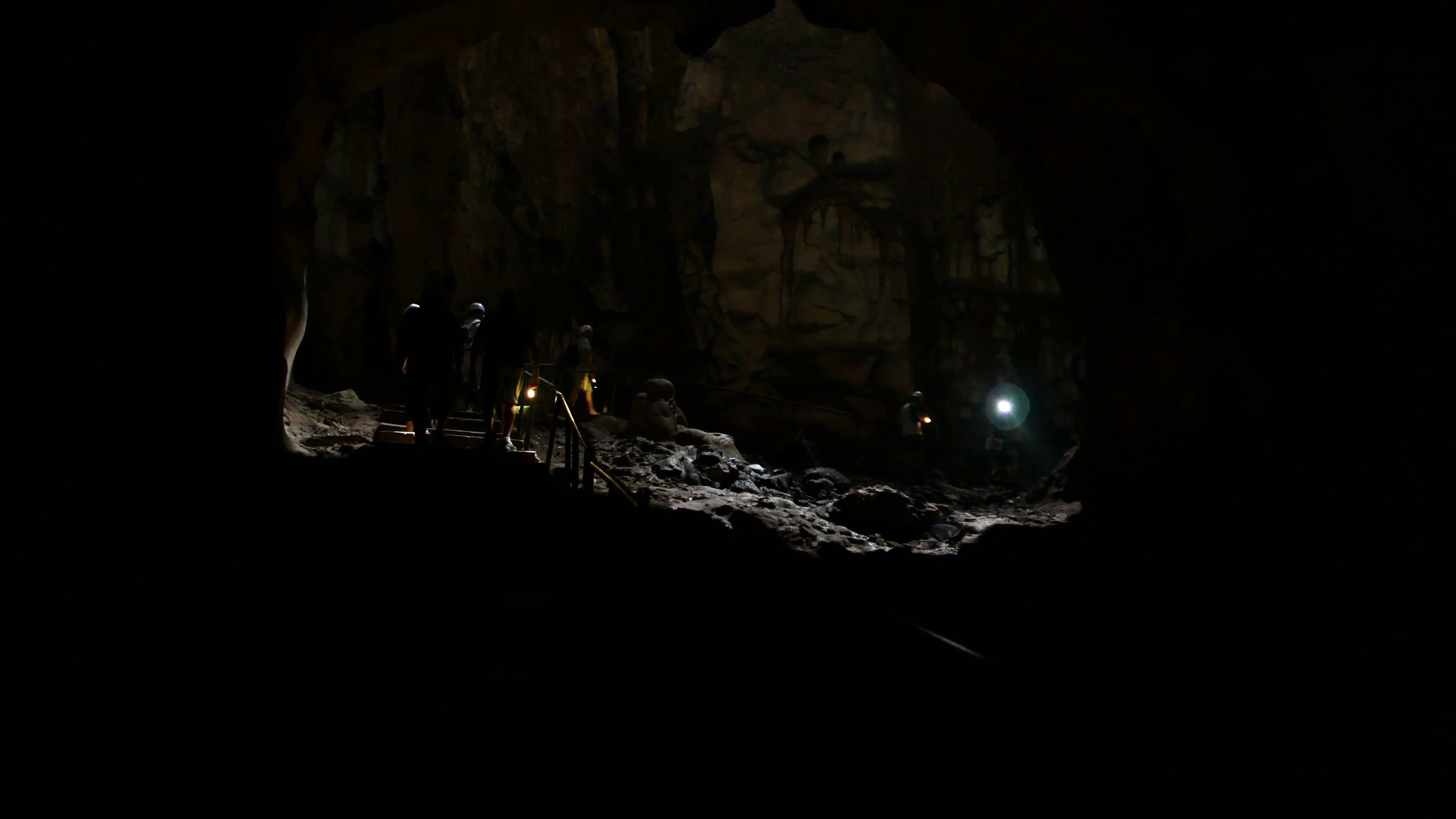 Cavers group walking in dim light under mystical cave vaults, dark ...