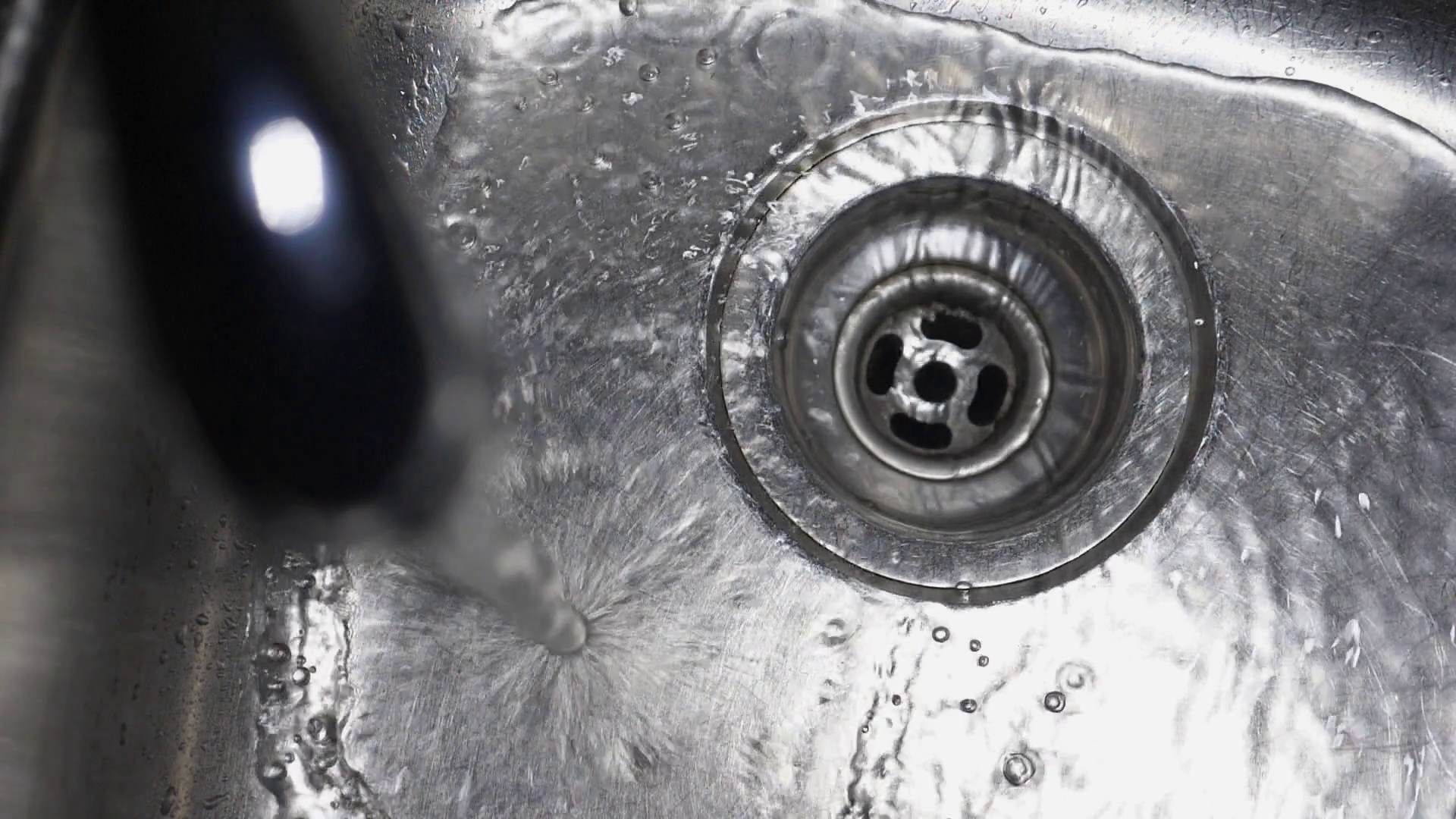 Slow motion kitchen sink. Overhead closeup of water stream and water ...
