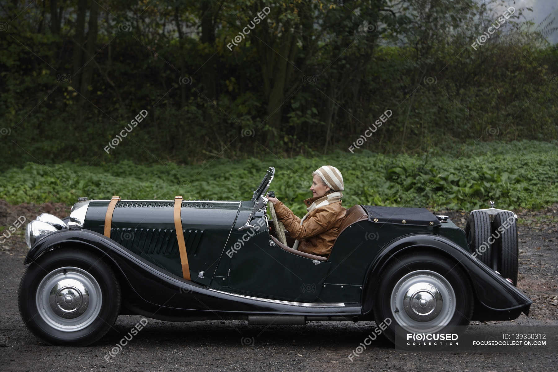 Senior woman driving antique car — Stock Photo | #139350312
