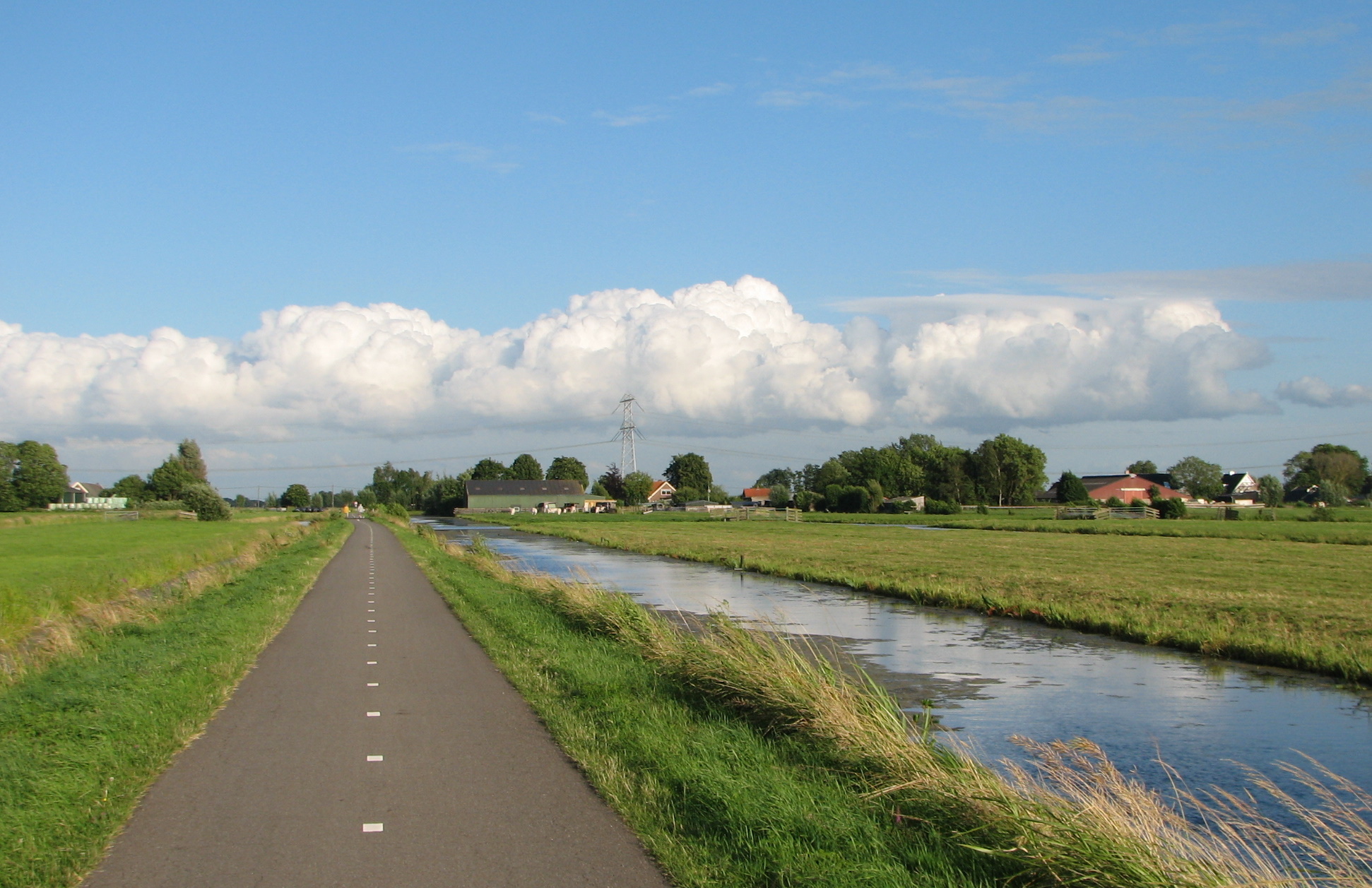 Fietspad naar Achterbroek met polder en witte wolkenformatie - Buurtlink