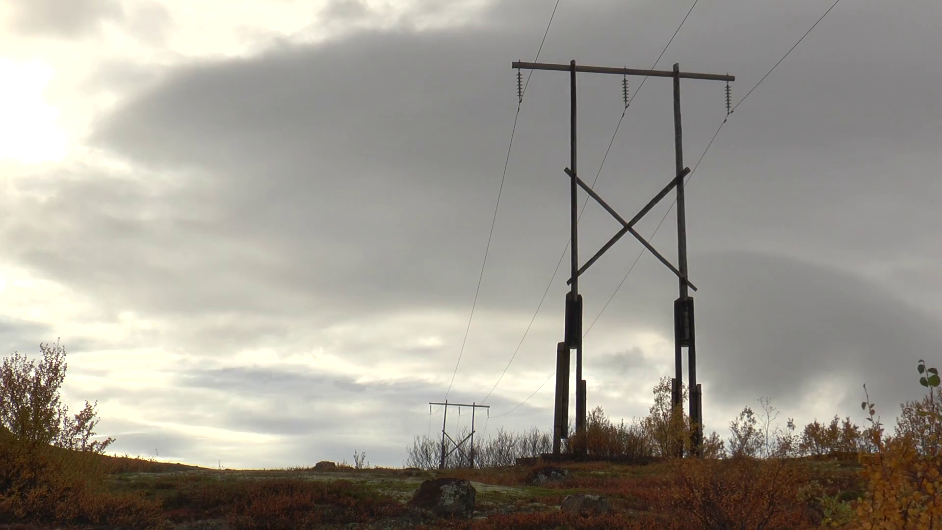 Electric poles in the autumn tundra on the background of dark cloudy ...