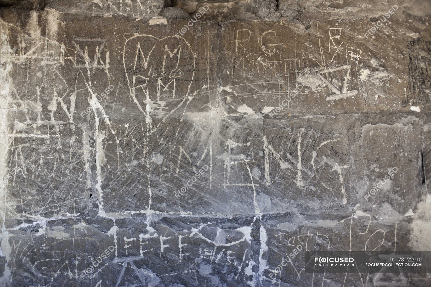 Handwritten graffiti etched into stone wall — Stock Photo | #178122910
