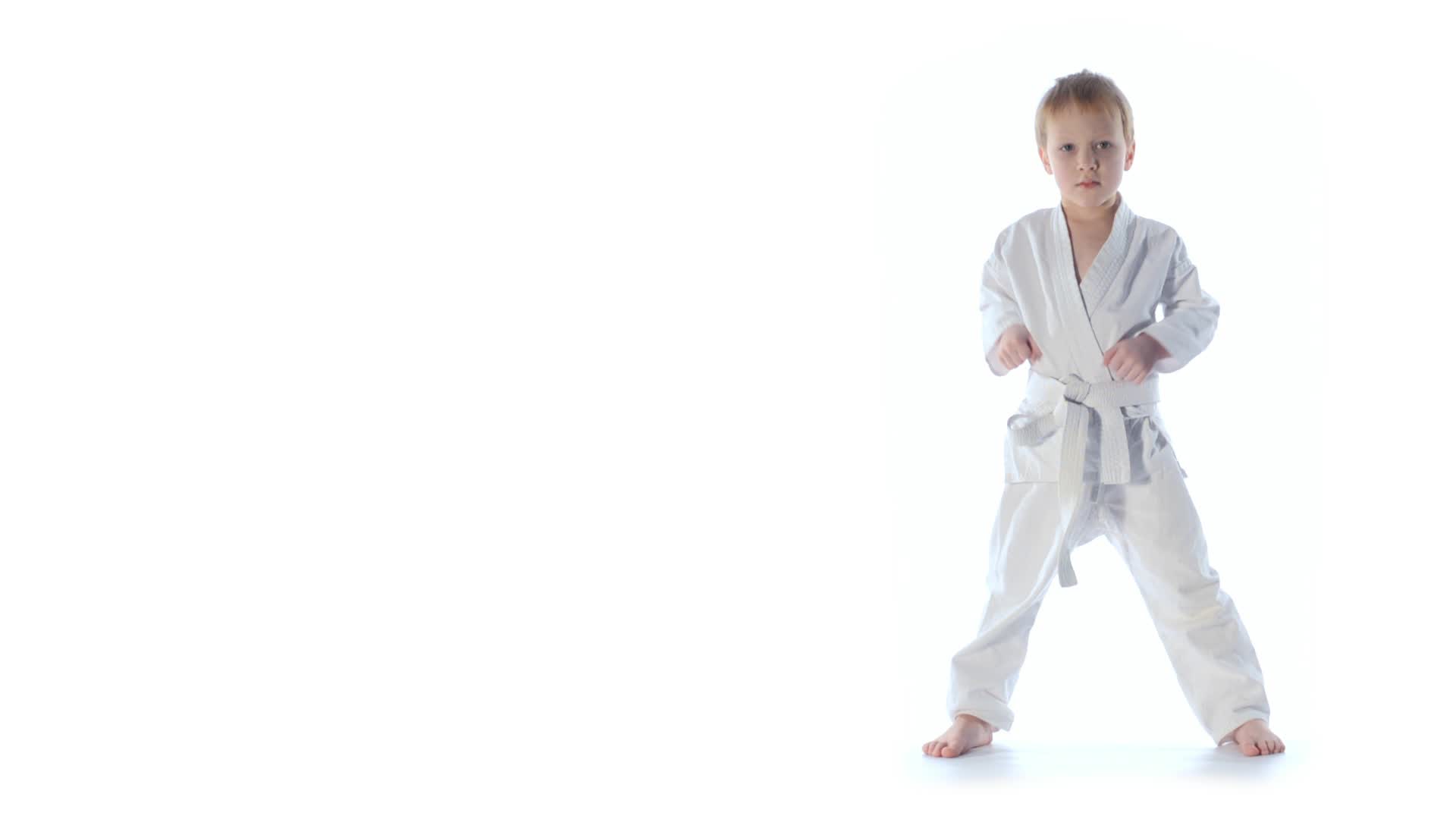 Video: Karate boy exercising isolated against white background ...